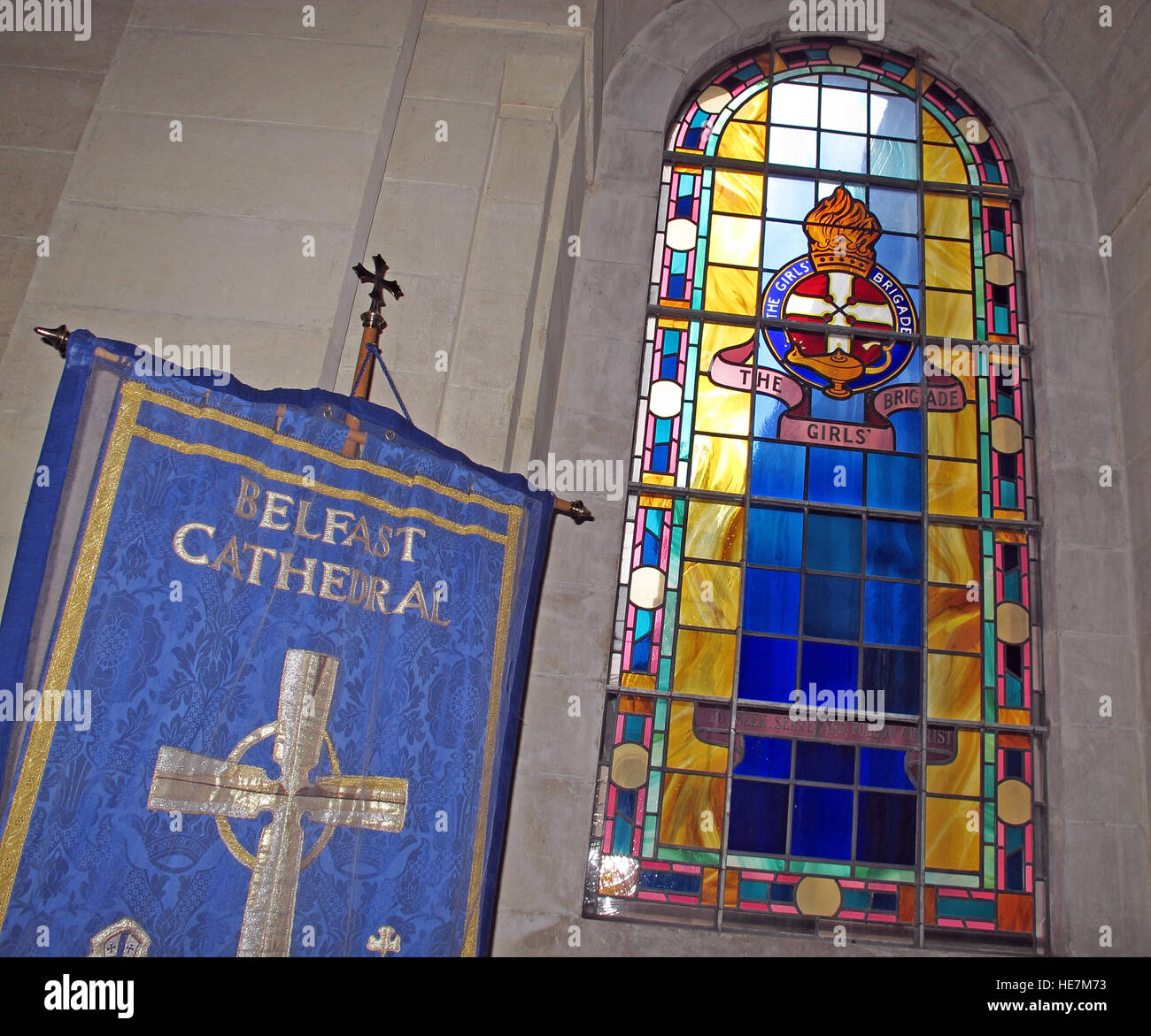 St Annes Belfast Cathedral Interior, Mädchen Brigade befleckten Glasfenster und Flagge Stockfoto