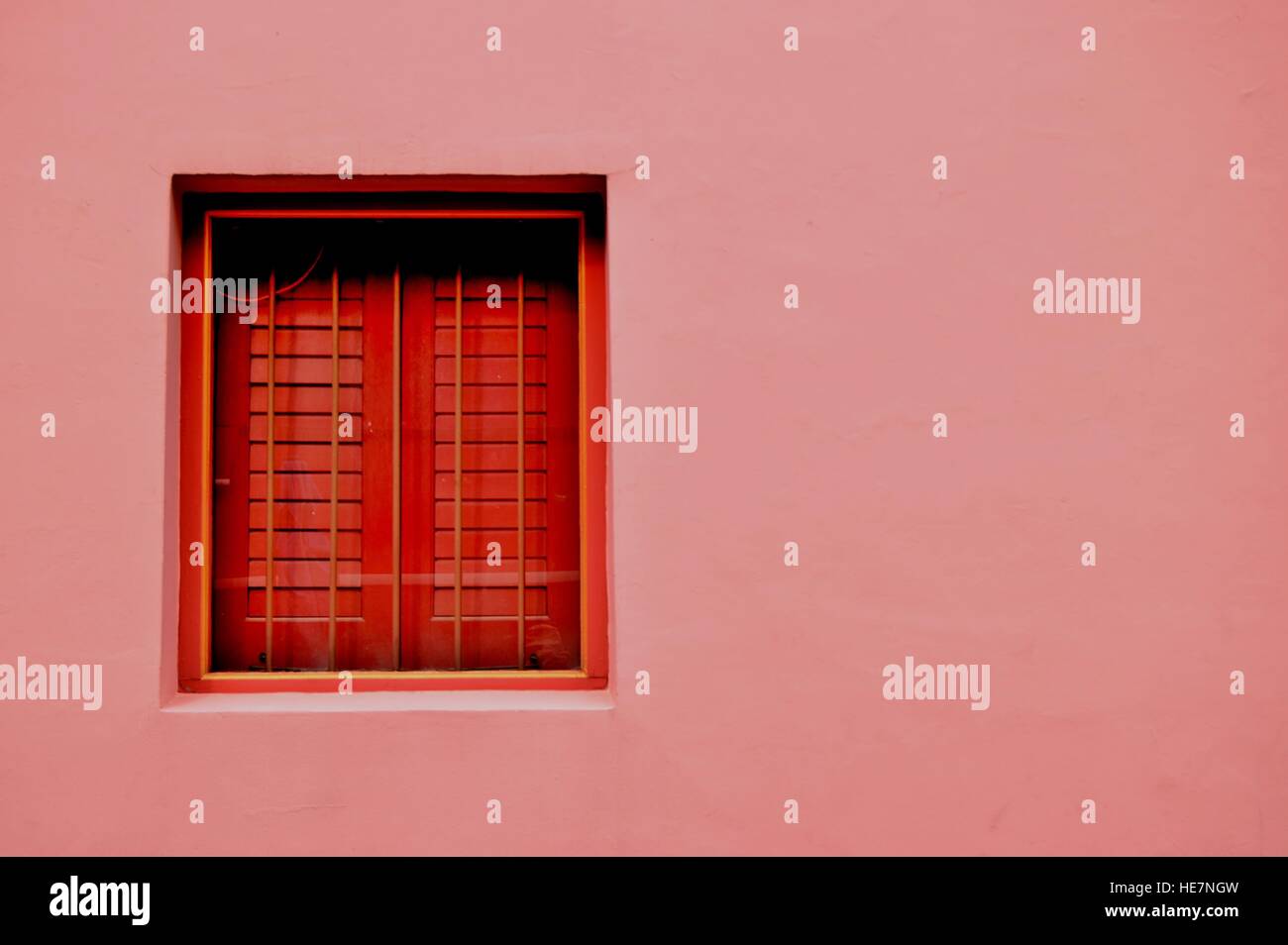 Rosa Wand mit rotem Fenster in Emerald Hill, Singapur Stockfoto