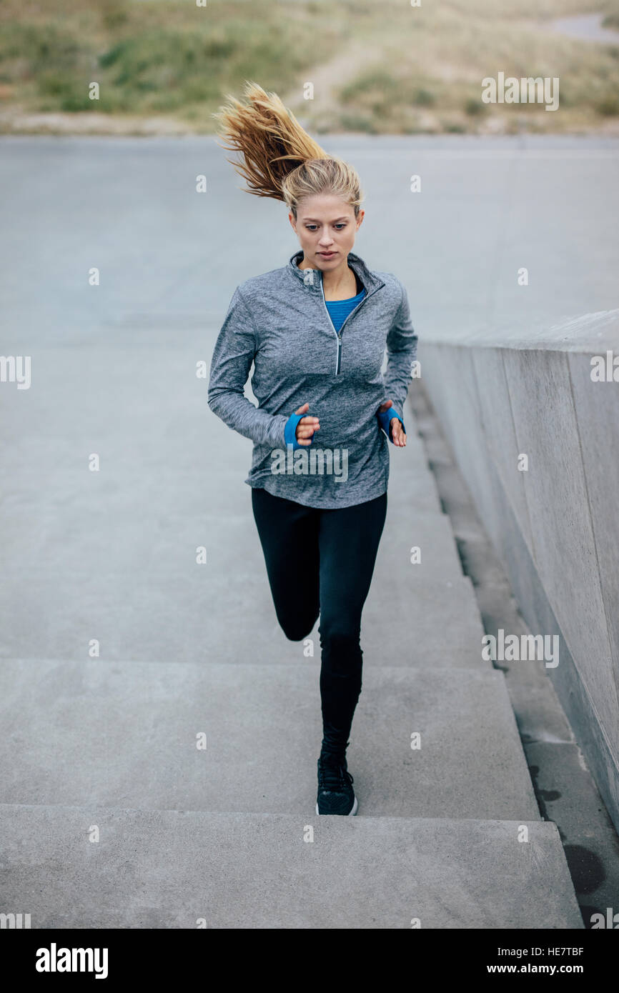 Fitness-Frau, die auf Treppen läuft. Kaukasisches weibliches Modell, das auf Stufen arbeitet. Stockfoto