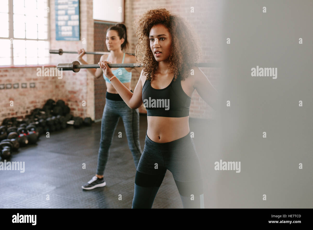 Fitness-Klasse mit Frau auszuüben. Frauen trainieren Sie im Fitnessraum mit Langhantel. Stockfoto