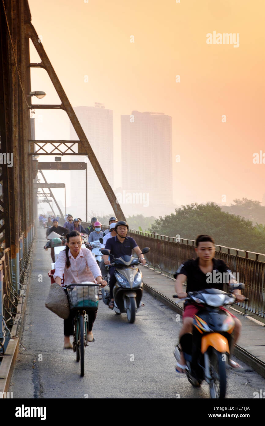 Pendler mit Motorrädern auf der langen Bien-Brücke unter rauchigen Bedingungen mit hohen Fahrzeugemissionen, Hanoi, Vietnam, Asien Stockfoto