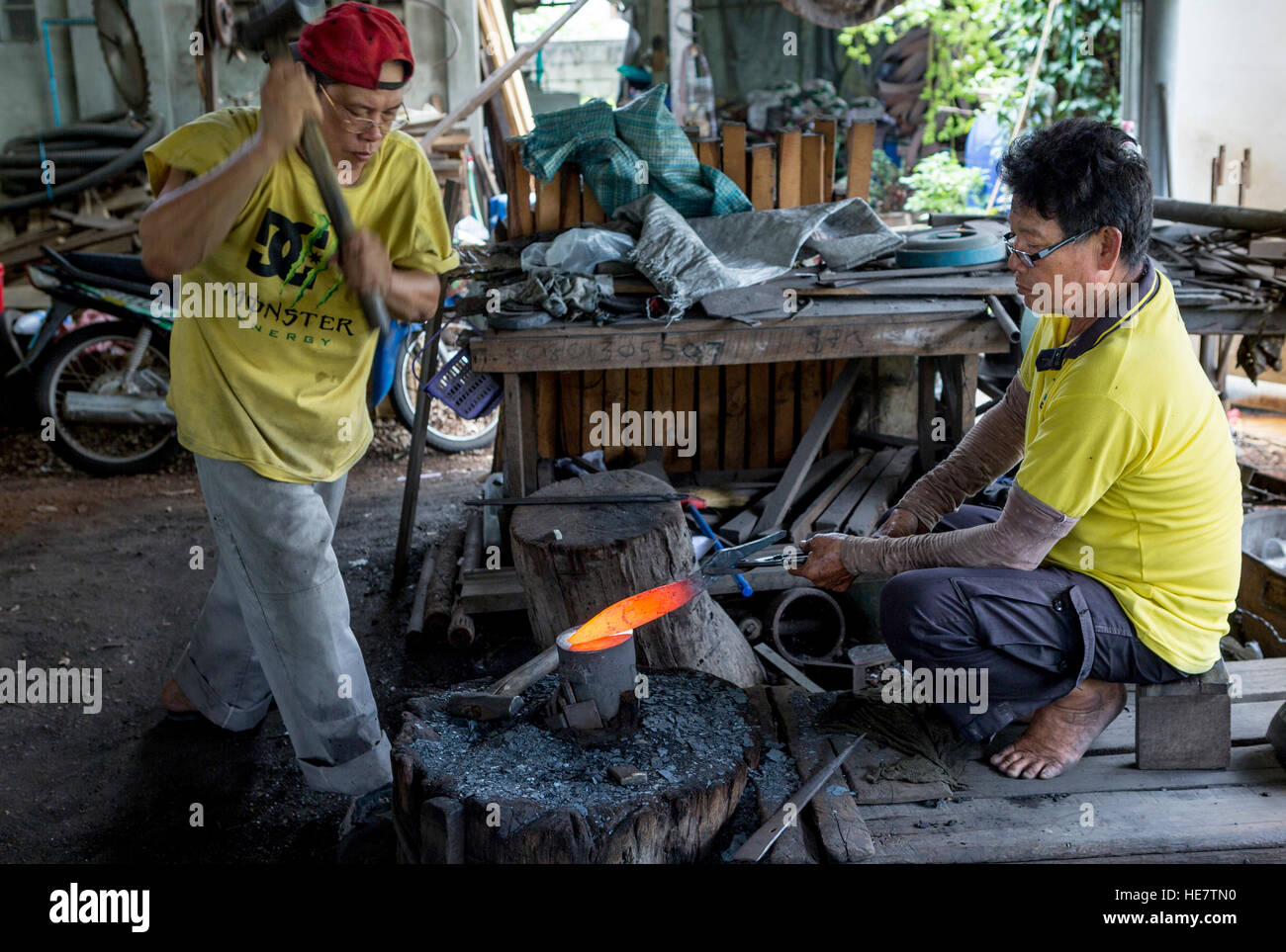 Ajam Kor Neekow und seine Schmiede/bladesmiths Eine traditionelle Schwert an ihre Schmiede in Lampang, Thailand Stockfoto