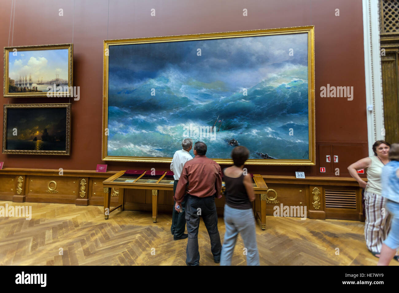 Sankt PETERSBURG, Russland - 26. Juli 2014: Besucher vor dem Gemälde "die neunte Welle" von Ivan Aivazovsky Stockfoto