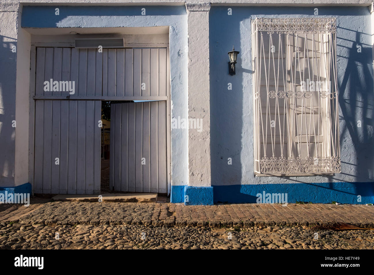 Fassade mit typischen Eisenbarren auf die Fenster und die offene Seitentür, Trinidad, Kuba Stockfoto