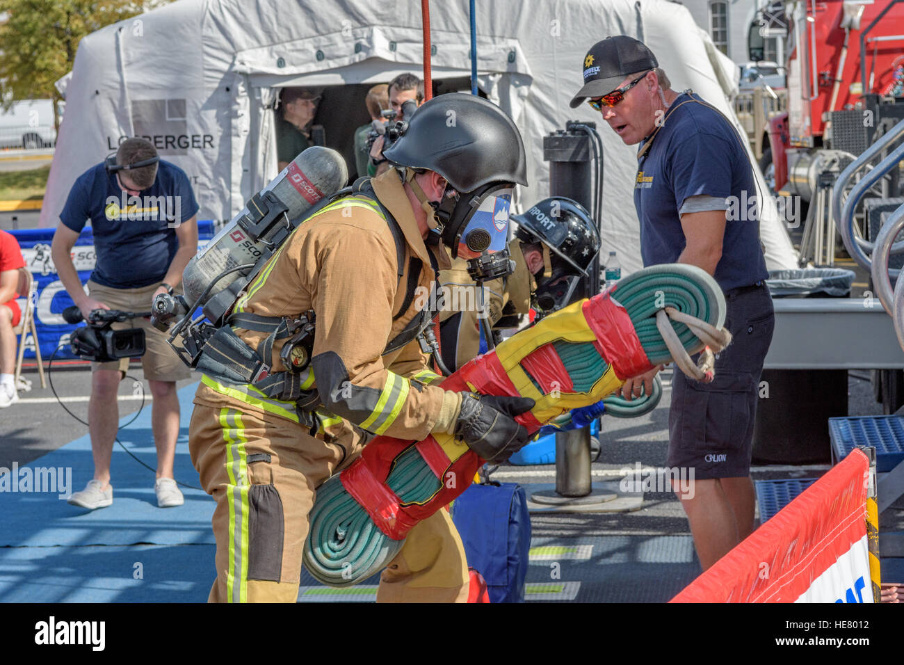 Feuerwehrleute in voller drehen Sie das Zahnrad, die wartet, um zu konkurrieren. Stockfoto
