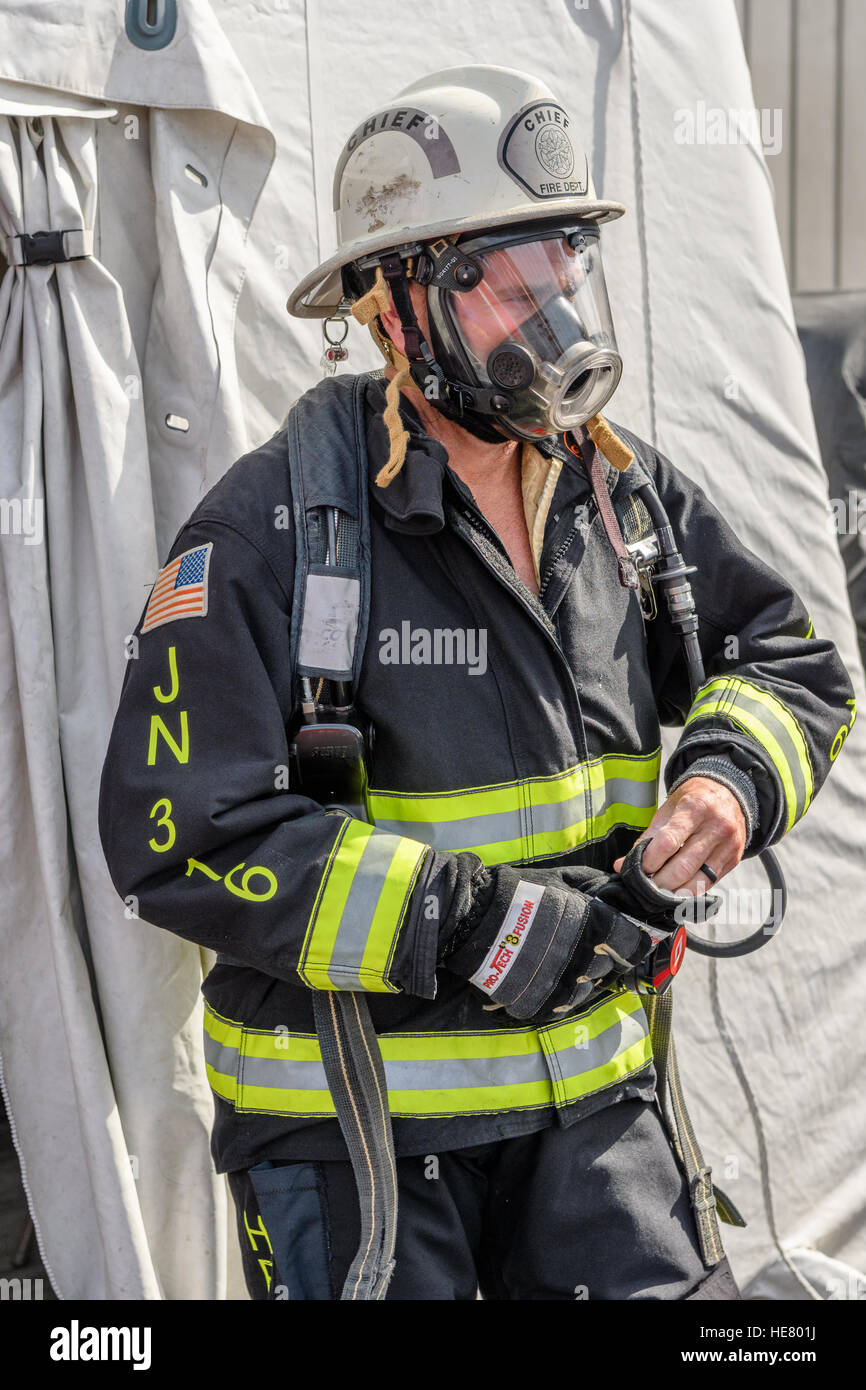 Feuerwehrmann in voller drehen Sie das Zahnrad einschließlich Sauerstoff Maske, Mantel und Helm. Stockfoto