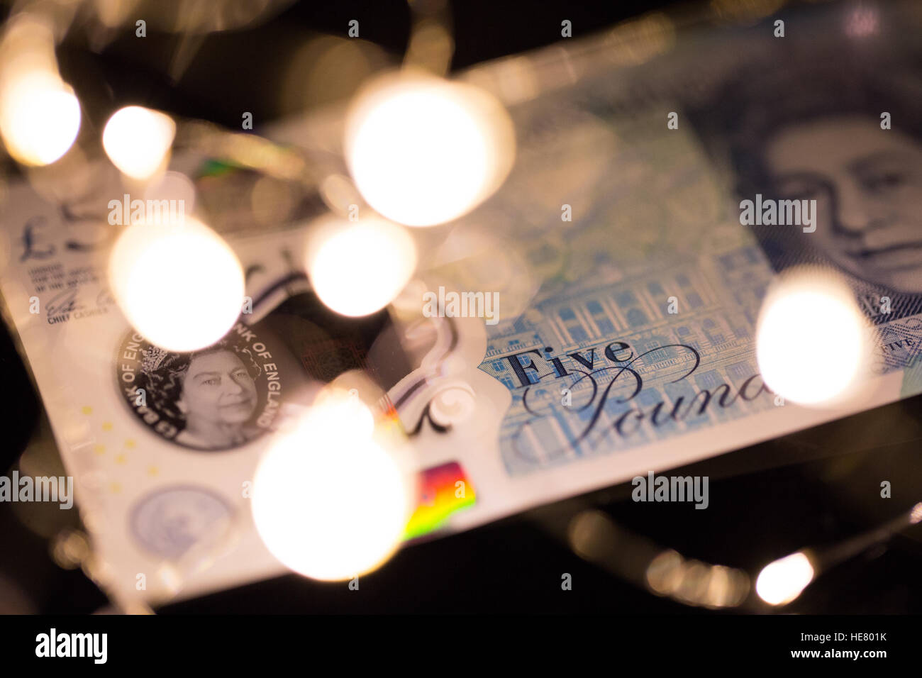 Nahaufnahme von der neuen 2016 Polymer-fünf-Pfund-Note mit verschwommenen Lichtern im Vordergrund. Stockfoto