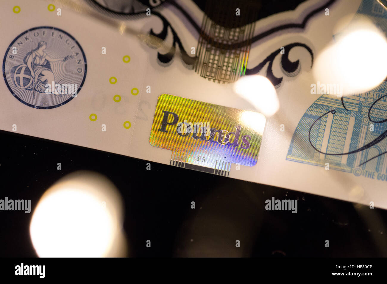 Nahaufnahme von der neuen 2016 Polymer-fünf-Pfund-Note mit verschwommenen Lichtern im Vordergrund. Stockfoto