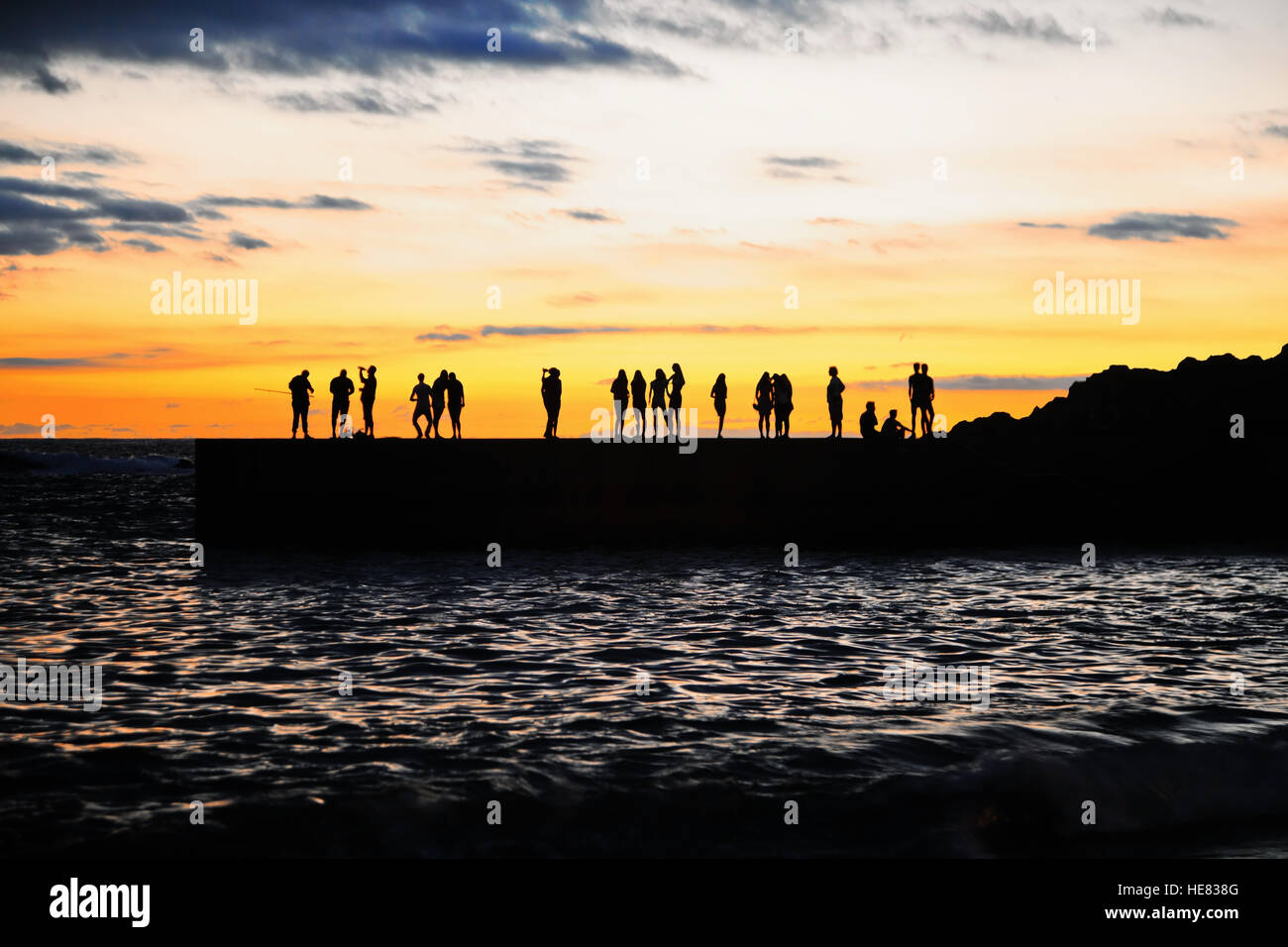 Menschen-Silhouetten auf dem Meer Pier bei Sonnenuntergang. Kanarische Insel Teneriffa. Spanien Stockfoto