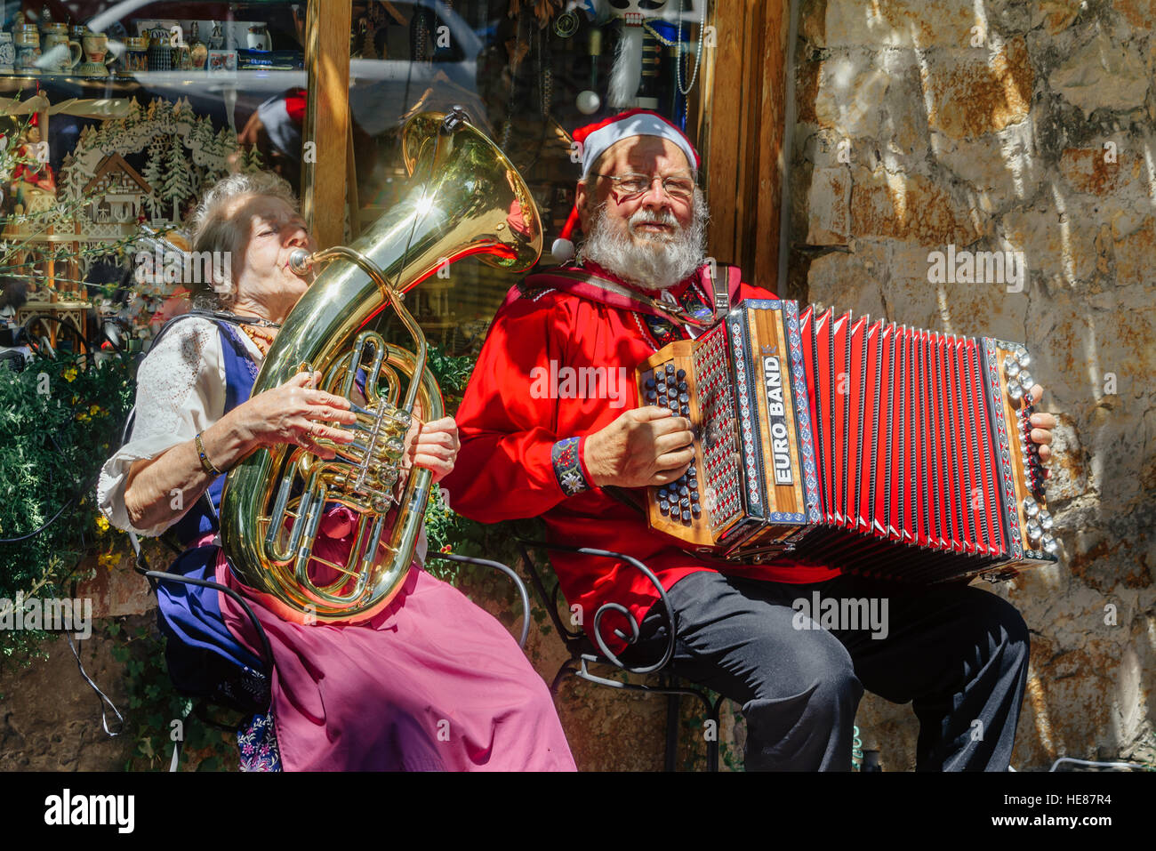 Santa Claus und seine Assistentin spielen Musikinstrumente während Straßenmusik zu Weihnachten in Hahndorf, SA, Australien. Stockfoto