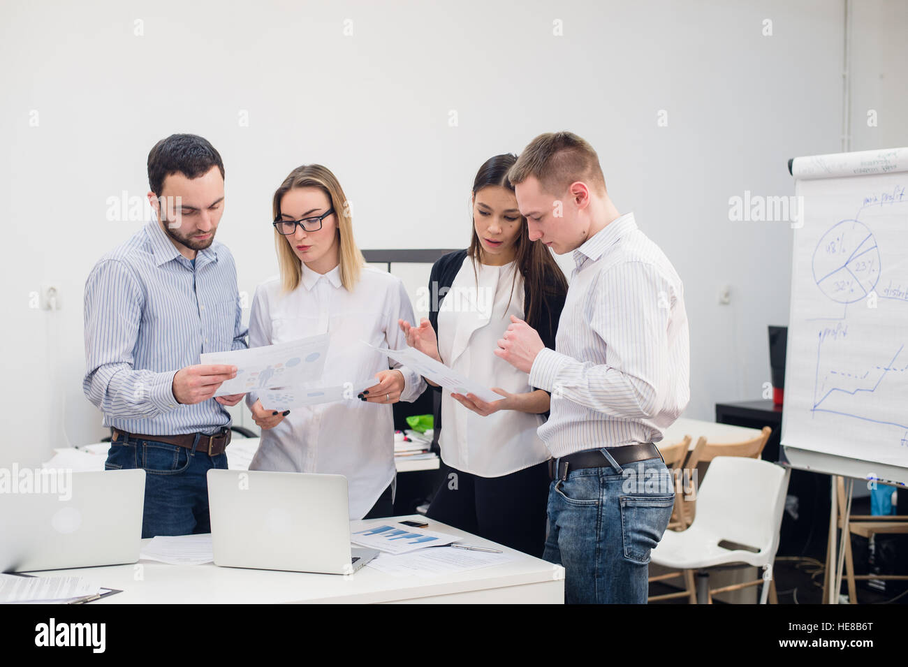 Gruppe von vier verschiedenen Männern und Frauen in Freizeitkleidung im Gespräch im Büro Stockfoto