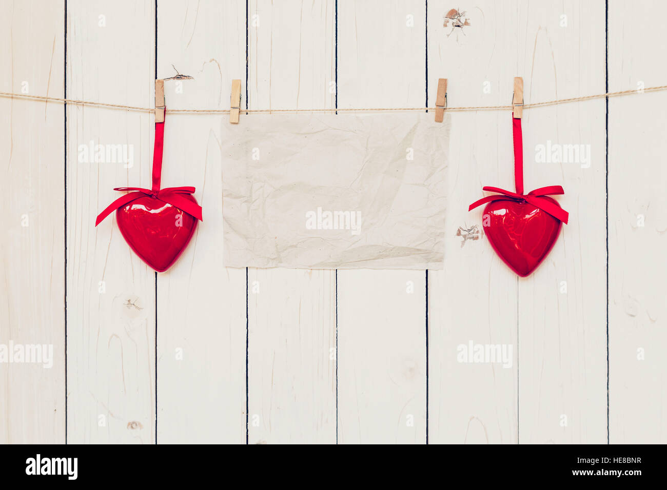 Leere Altpapier und rotes Herz Holz hängen an Bord Hintergrund mit dem Raum. Stockfoto