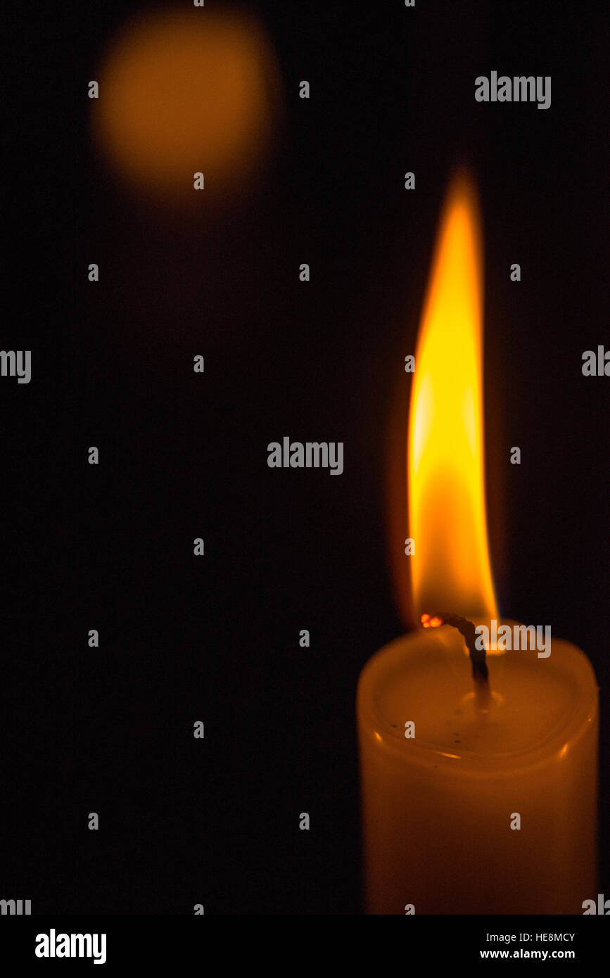 brennende Kerze mit schwarzem Hintergrund Stockfoto