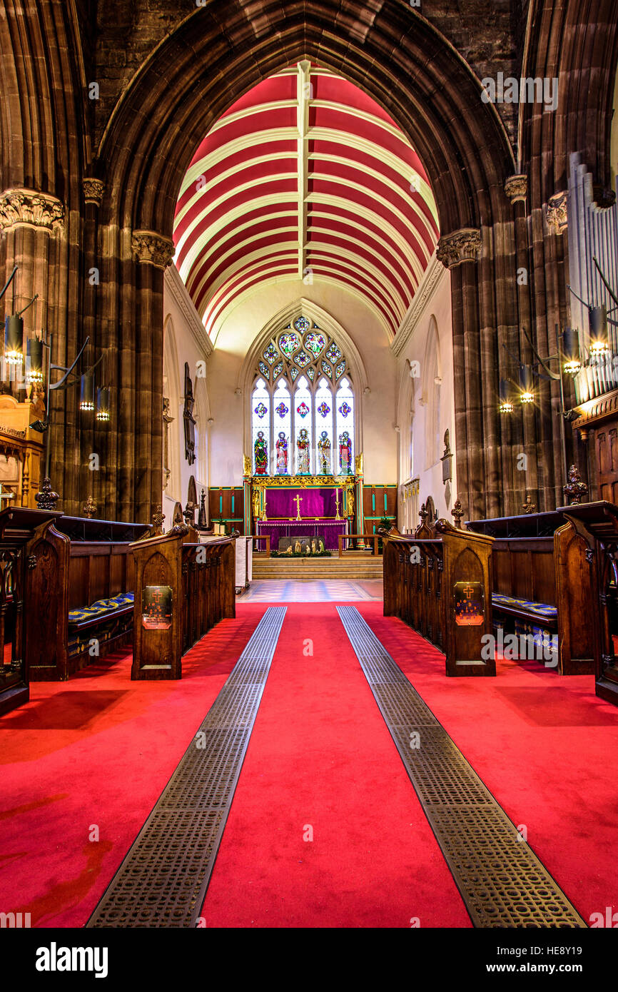 Innerhalb einer alten Kirche. Bogen Steinarbeiten. Fleck-Glas-Fenster Stockfoto