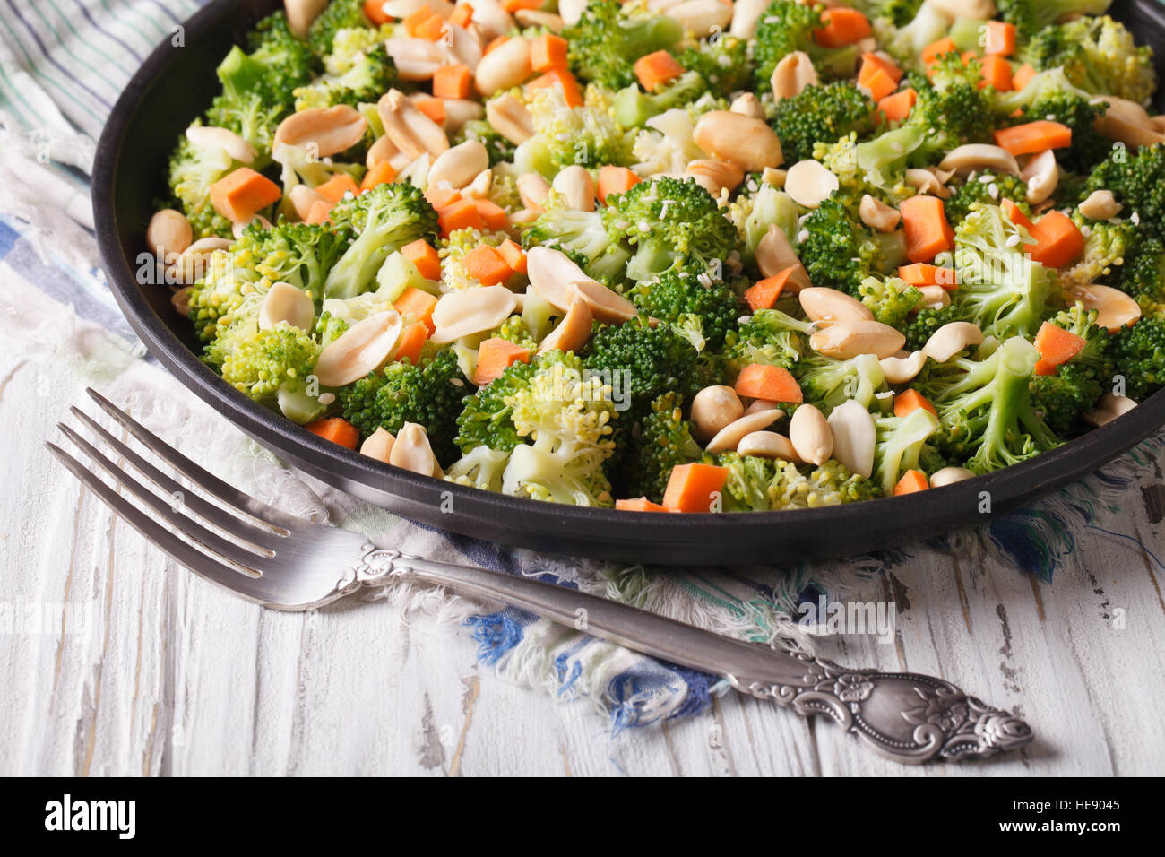 Sommersalat mit Brokkoli, Karotten und Erdnüssen Nahaufnahme auf einer Platte. horizontale Stockfoto