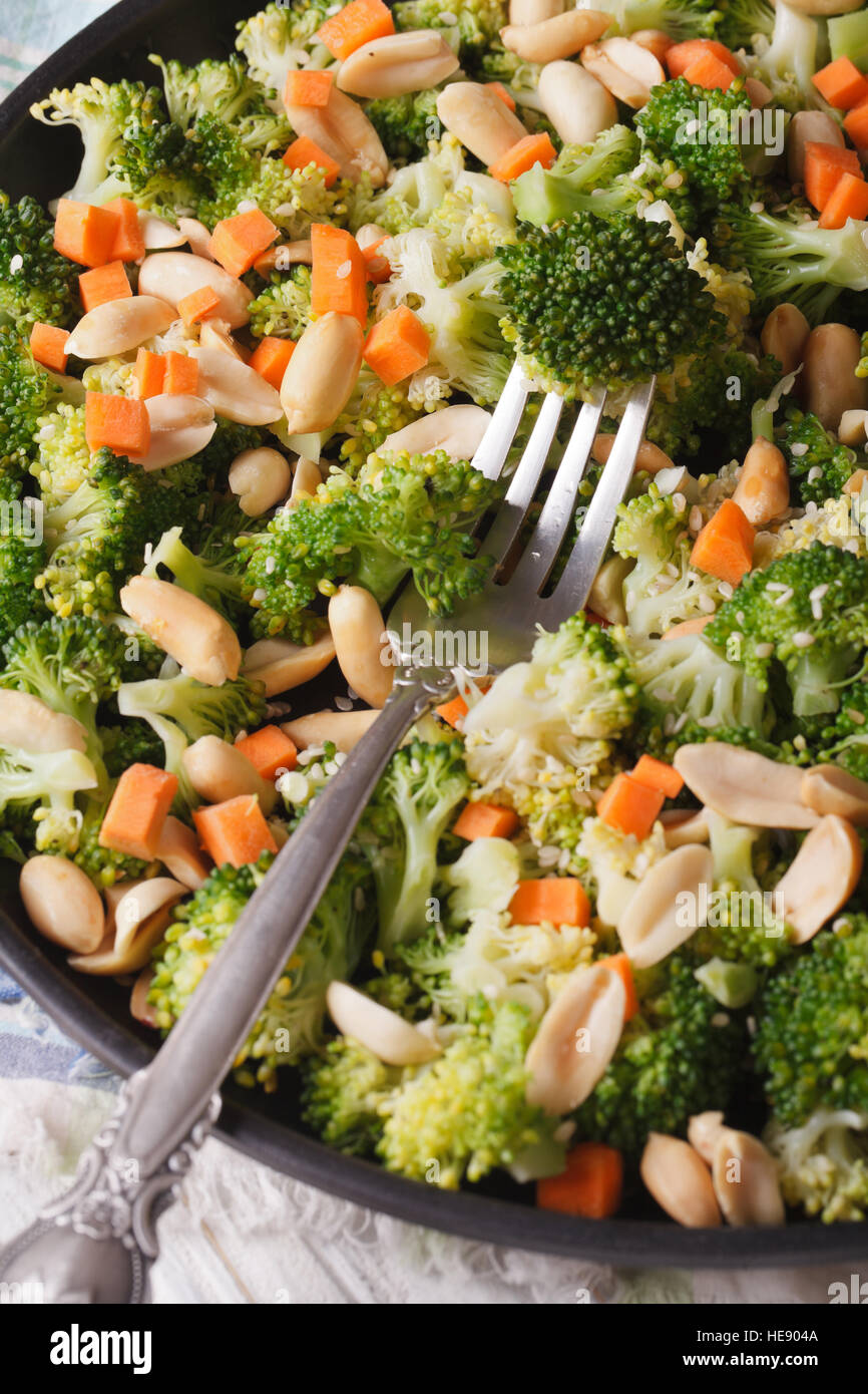 Diätetische Salat mit Brokkoli, Karotten und Erdnüssen Nahaufnahme auf einer Platte. vertikale Ansicht von oben Stockfoto