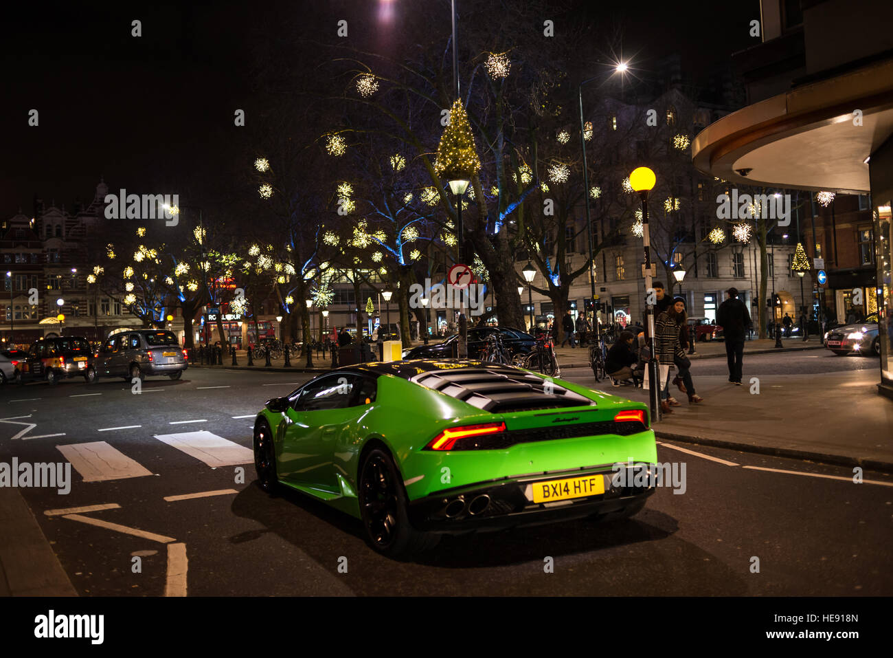 Nachtansicht des Sloane Square mit leichten Weihnachtsschmuck und große grüne Supersportwagen Lamborghini vorbei. Chelsea, London, UK Stockfoto