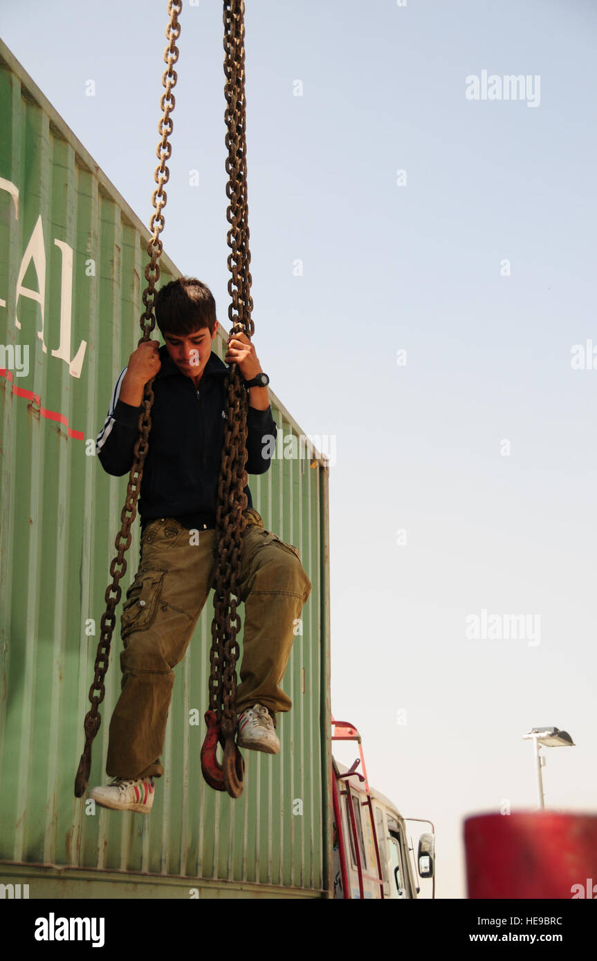 Beim Transport Cargo Trailer am internationalen Flughafen von Kabul, Kabul, Afghanistan, 3. Oktober 2011 ist ein afghanischer Junge mit einem Kran gehievt. Die Trucks machten eine routinemäßige Lieferung an 438th Air Expeditionary Wing. Stockfoto