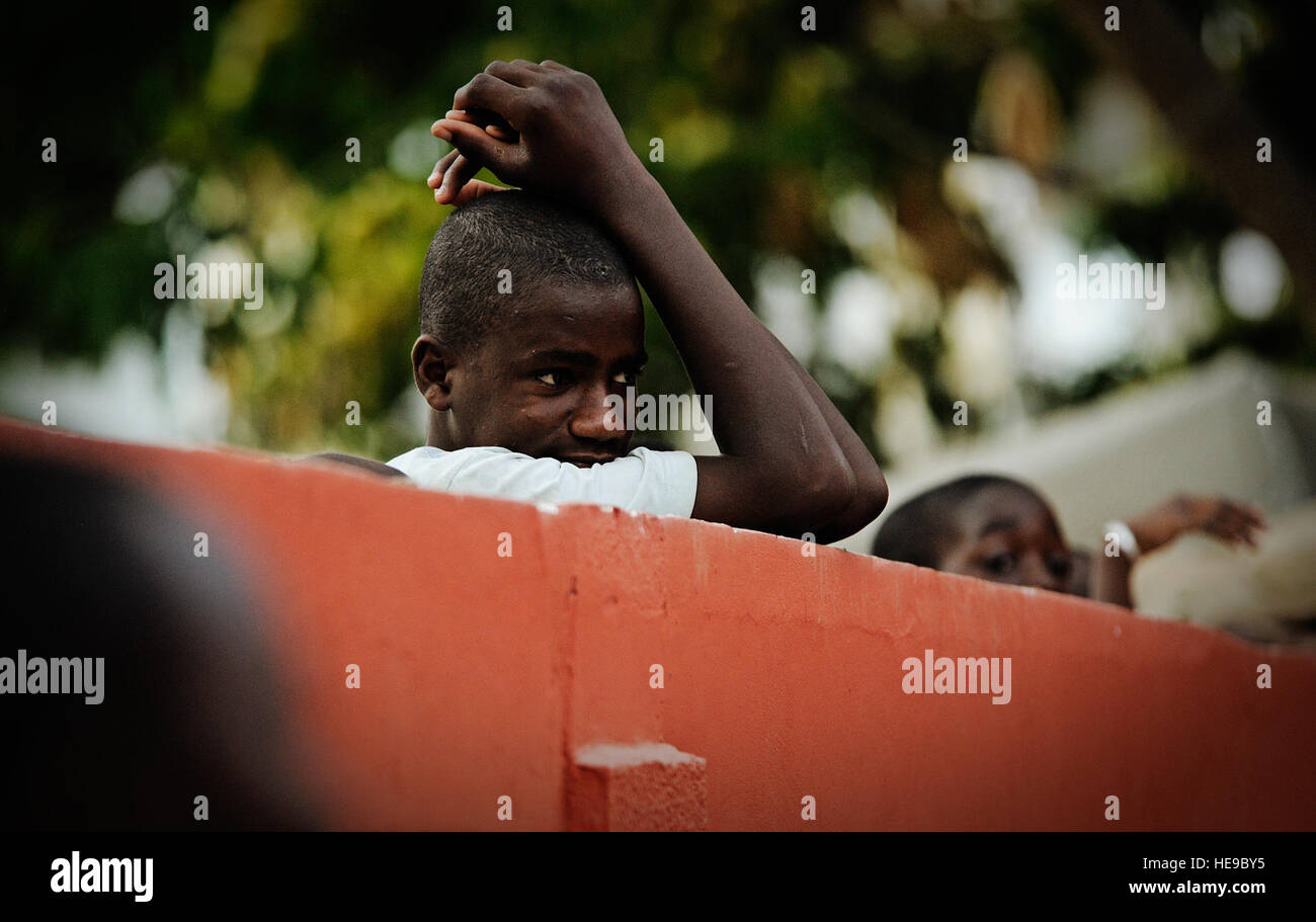 Ein lokaler Kind blickt über einen Sicherheitszaun um eine bessere Sicht der US-Luftstreitkräfte in Europa und Afrika Air Force Band Konzert in Dakar, Senegal, 13. Juni 2014, an einer lokalen Universität erhalten. USAFE-AFAFRICA Flieger sind im Senegal für afrikanische Partnerschaft Flug, ein Programm zur Verbesserung der Kommunikation und Interoperabilität zwischen regionalen Partnern in Afrika. Die Band spielt mehrere Locations in der Umgebung, Kindern und Musikern durch die universelle Sprache der Musik zu begeistern.  Staff Sgt. Ryan Crane) Stockfoto
