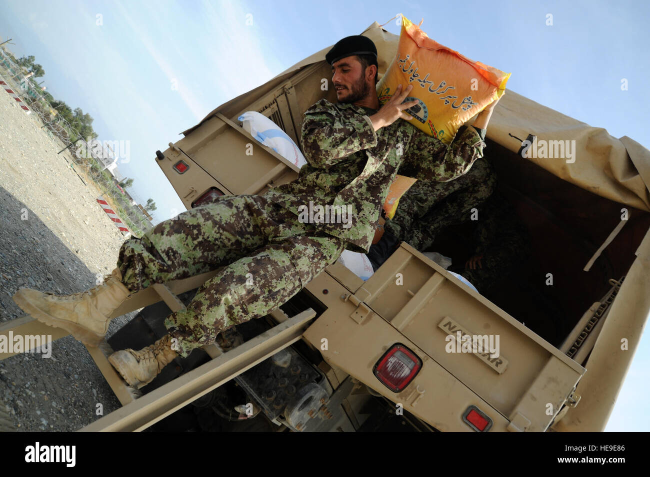 Ein Soldat der afghanischen Nationalarmee entlädt Reis von der Ladefläche eines Lastwagens auf Forward Operating Base Fenty, Jalalabad, Afghanistan, 10. Oktober 2011. Die Lieferungen Verwendungsnachweis für eine Bekämpfung Nachschub Mission Barge Matal im nördlichen Kunar Tal. Stockfoto