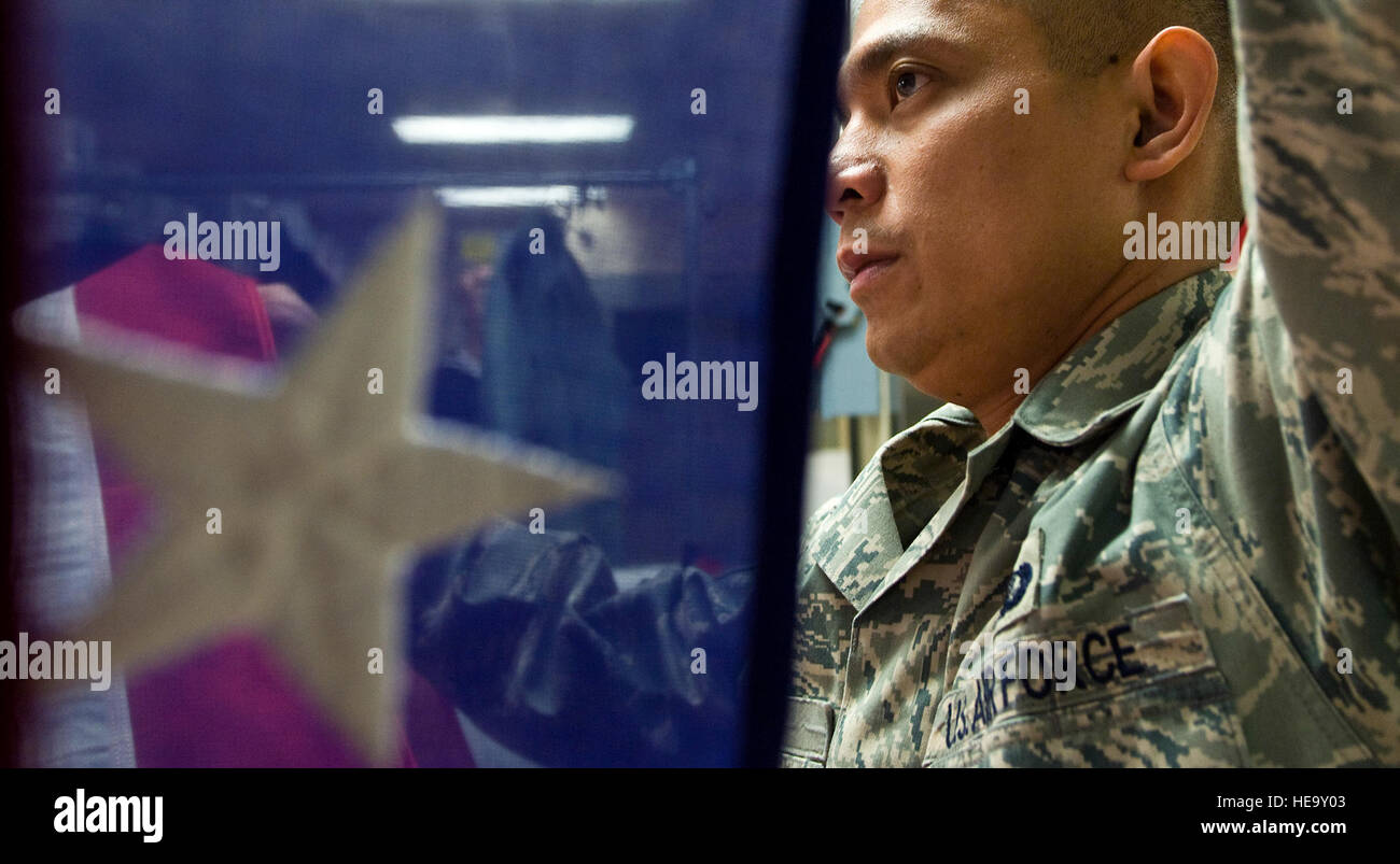 Techn. Sgt Willard Rico speist eine US-Flagge in einer Pressmaschine dient zum Bügeln Sie die Flaggen knitterfrei über Schatullen während der würdige Übertragung bleibt Versandprozess bei Charles C. Carson Center für Leichenhalle Angelegenheiten, Dover Air Force Base, Delaware, 31.März platziert werden. Charles C. Carson Center ist die größte Anlage für die Gelenk-Service Leichenhalle des Verteidigungsministeriums und der einzige in den kontinentalen Vereinigten Staaten. Techn. Sgt. Rico wird von der 60. Kraft Unterstützung sq, Travis AFB, CA. /Staff Sgt Bennie J. Davis III bereitgestellt) Stockfoto