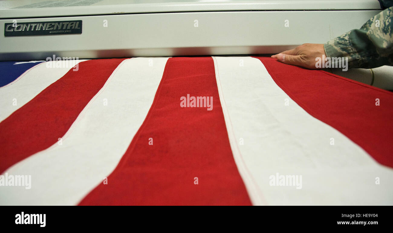 Techn. Sgt Willard Rico speist eine US-Flagge in einer Pressmaschine dient zum Bügeln Sie die Flaggen knitterfrei über Schatullen während der würdige Übertragung bleibt Versandprozess bei Charles C. Carson Center für Leichenhalle Angelegenheiten, Dover Air Force Base, Delaware, 31.März platziert werden. Charles C. Carson Center ist die größte Anlage für die Gelenk-Service Leichenhalle des Verteidigungsministeriums und der einzige in den kontinentalen Vereinigten Staaten. Techn. Sgt. Rico wird von der 60. Kraft Unterstützung sq, Travis AFB, CA. /Staff Sgt Bennie J. Davis III bereitgestellt) Stockfoto