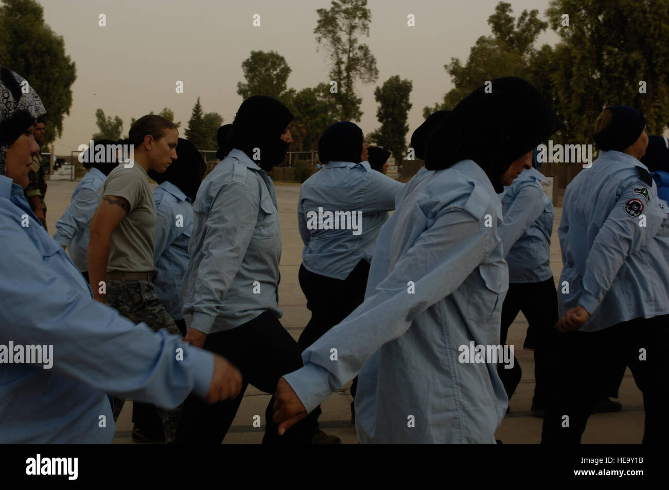 US Army Spc Jennifer Swierk, gebürtig Fairbanks, Alaska, der Brigade spezielle Truppen Bataillon, 10th Mountain Division, Fort-Trommel, N.Y., bereitgestellt auf Forward Operating Base Krieger, Kirkuk, Irak, hilft weibliche irakischen Auszubildenden mit ihrer marschieren auf die irakischen Kirkuk Polizeiakademie, 26. August 2008. Stockfoto