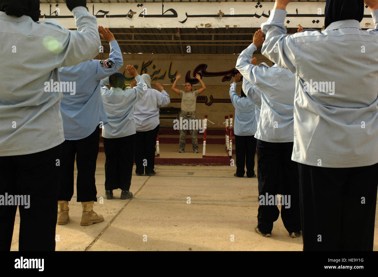 US Army Spc Jennifer Swierk, ein Fairbanks, Alaska, native, Brigade spezielle Truppen Bataillon, 10th Mountain Division, Fort-Trommel, N.Y., bereitgestellt auf Forward Operating Base Krieger, Kirkuk, Irak, führt körperliches Trainingsübungen für irakische weibliche Auszubildende bei Kirkuk irakischen Polizeiakademie, 26. August 2008. Stockfoto