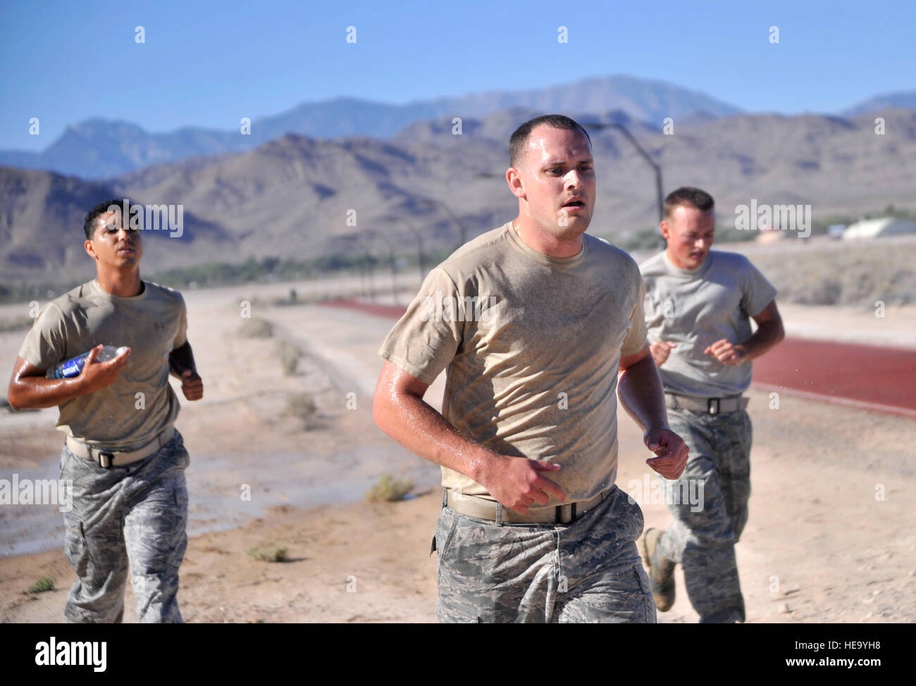 Techn. Sgt. Michael McGuire, 99. Contracting Squadron Auftraggeber Spezialist, links, Staff Sgt. James Eustace, 99. Nachteile contracting-Spezialist, center, Staff Sgt Derek Urban, 99. Nachteile contracting-Spezialist, laufen in Richtung das letzte Hindernis der Krieger Herausforderung nach immer mit Wasser besprüht die allererste Krieger Herausforderung 22. August 2014, auf Creech Air Force Base, Nevada Die Krieger-Herausforderung ist Teil des Lebens einer Krieger-Kampagne, die die vier Säulen der Ausfallsicherheit für diejenigen zu fördern, die teilnehmen soll.  Flieger 1. Klasse Christian Clausen Stockfoto