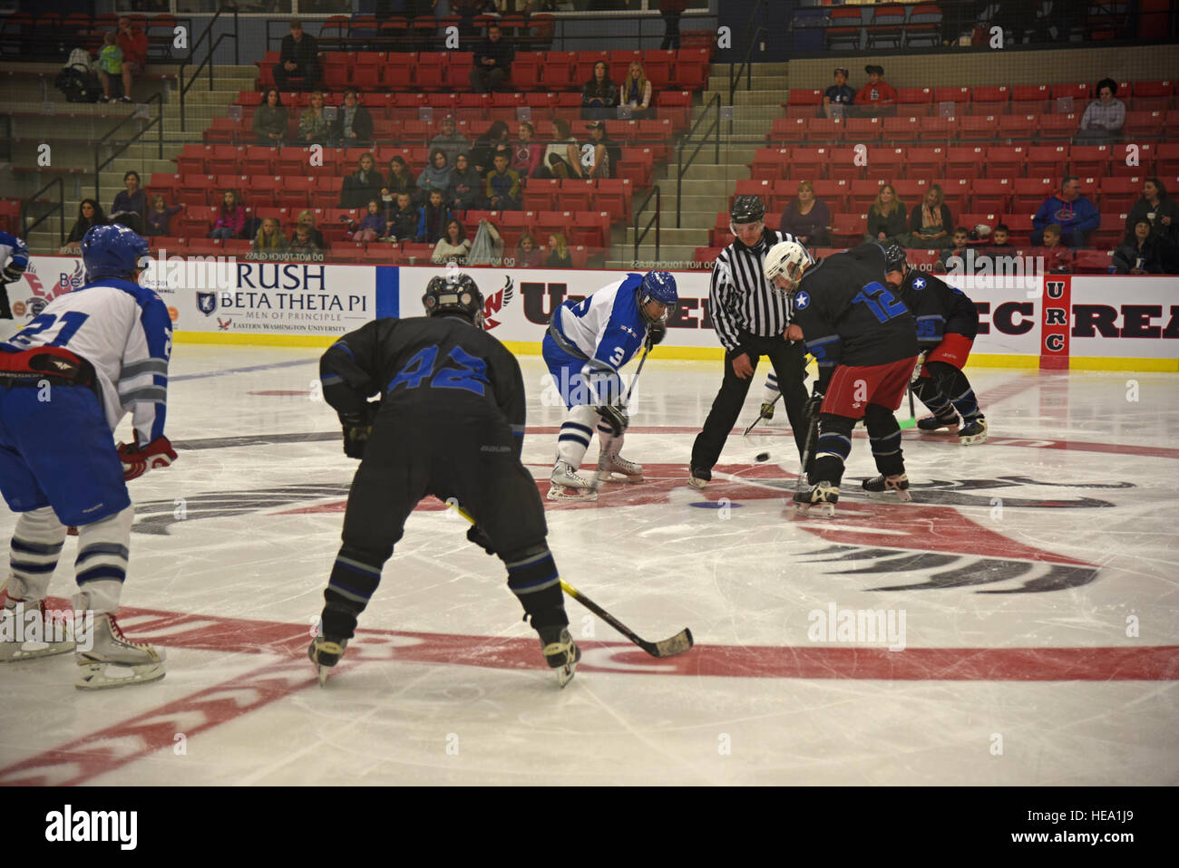 Die Fairchild Air Force Base Falcons bereiten für Spiel wie der Puck am Anfang der ersten Periode von blau und weiß Spiel 23. Oktober 2015, am Eastern Washington University Recreation Center Eisbahn in Cheney, Washington gesunken ist Das blaue Team, gecoacht von Oberst Brian McDaniel, 92. Air Refueling Wing Commander und Chief Master Sgt. Christian Pugh, 92. ARW Befehl Chef, behauptete einen 5: 3-Sieg über das weiße Team. Airman 1st Class Mackenzie Richardson) Stockfoto