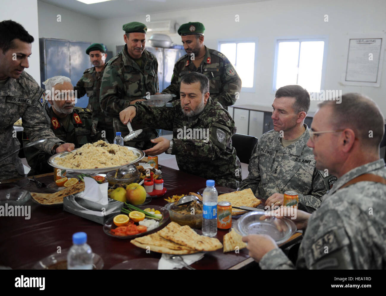 Gen Bismillah Mohammadi, Center, Afghan National Army (ANA) Chef des Stabes, dient Generalleutnant William B. Caldwell IV, zweiter von rechts, Kommandant, NATO Training Mission - Afghanistan (NTM-A) während eines Mittagessens ein ANA-Camp in Kandahar, Afghanistan, 3. Januar 2010. Gen Mohammadi eingeladen Generalleutnant Caldwell Treffen mit ANA und Koalitionstruppen auf verschiedenen ANA Beiträge in der gesamten Region. Beide Generäle erhielt Mission Updates und Feedback von ANA und Koalition zwingt auf Ausbildung, der Lebensqualität und der Bekämpfung des Terrorismus. Staff Sgt Larry E. Reid Jr., veröffentlicht) Stockfoto