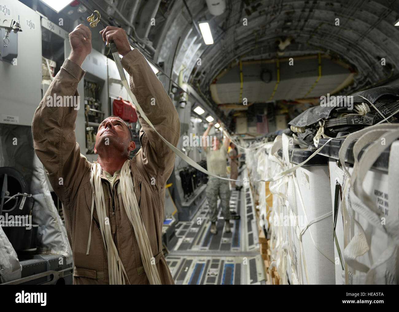 Armee SGT Chad Jernigan, US Army 11. Quartermaster Company Fallschirm Rigger, verbindet Fallschirmschnur mit einer Gabel in der Vorbereitung für eine humanitäre Airdrop über den Bereich des Amirli, Irak, 30. August 2014. Die Airdrop enthalten zwei c-17 Globemaster III und zwei c-130 Hercules liefert 10.545 Gallonen frisches Trinkwasser und 7.056 Halal Mahlzeiten bereit zu essen.  Staff Sgt. Shawn Nickel) Stockfoto