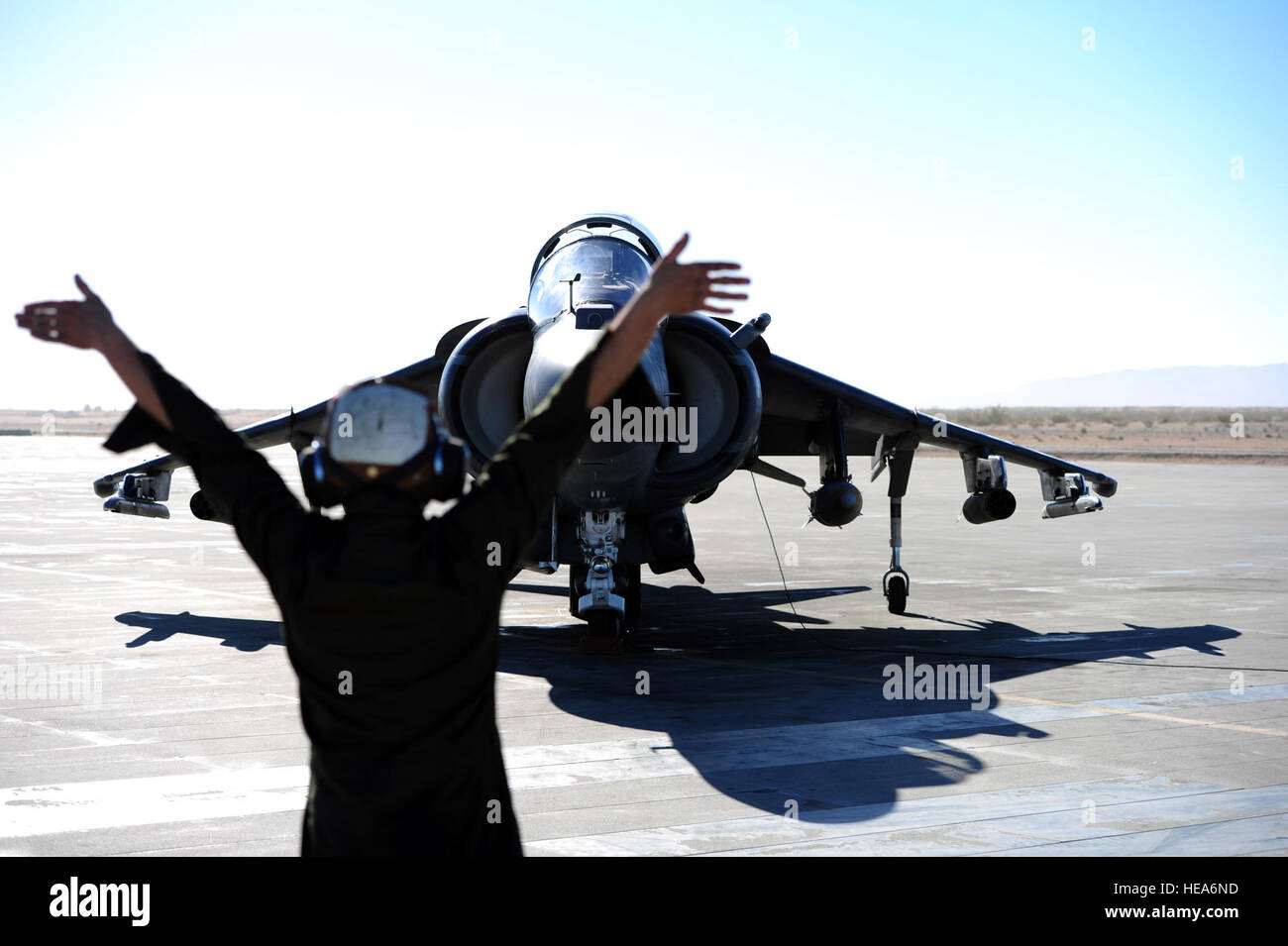 U.S. Marine Corps Lance Cpl. Blake Mullins, Marine Angriff Geschwader 214, Marine Corps Air Station, Yuma, Arizona, signalisiert Generalmajor Casey Elam in ein AV-8 b Harrier für Vorflugkontrollen während integrierte Übung 2-15 im Marine Corps Air Ground Combat Center (MCAGCC) Twentynine Palms, Kalifornien, 17. Februar 2015. MCAGCC führt relevant Leben Feuer kombinierte Waffen training, urbane Operationen und Gelenk/Koalition Integration Ebene Training, das fördert die operativen Kräfte Bereitschaft.  Techn. Sgt. Daniel St. Pierre Stockfoto