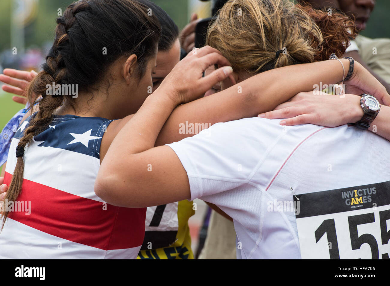 Verwundeten Krieger Athleten aus Großbritannien, Frankreich und die Vereinigten Staaten Gruppe umarmen nach gegeneinander in einem 100-Meter-Sprint bei der Invictus Games an der Lee Valley Athletics Centre, London, 11. September 2014. Leichtathletik ist eine verschiedene Sportarten, die mehr als 300 verwundete Krieger aus 13 Nationen antreten in einschließlich Bogenschießen, Rollstuhl-Basketball, Rennrad, indoor Rudern, Rollstuhl-Rugby, Schwimmen und Volleyball sitzen. Die Vision für die Invictus Games ist, nutzen die Kraft des Sports zu begeistern Erholung, Rehabilitation zu unterstützen und erzeugen ein breiteres Verständnis und Respekt Stockfoto