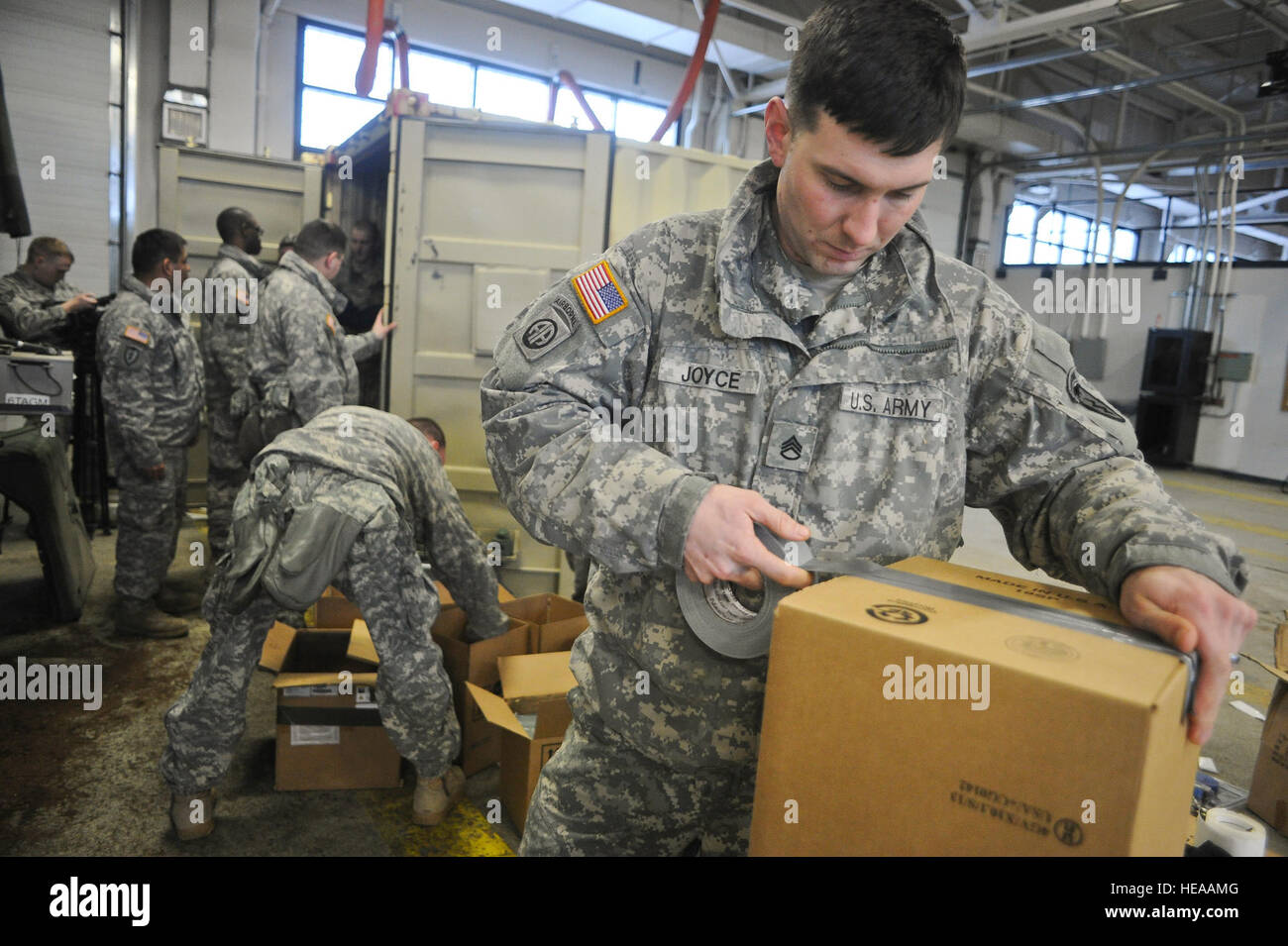 Armee-Personal-Sergeant Barry Joyce, ein Eingeborener von Martinsville, VA., Bänder der Küstenwache Container Inspektion Schulungsteam, eine Feld, um die Batterien zu laden, wie Kameraden 4th Infantry Brigade Combat Team (Airborne), 25. Infanterie-Division, U.S. Army Alaska und Küste Gardisten zugewiesen zugewiesen bereiten Sie Container mit Gefahrgut für den Transport zum Hafen von Anchorage und folgen auf Bewegung in der Joint Readiness Training Center in Fort Polk , La., auf gemeinsame Basis Elmendorf-Richardson, Alaska, 26. Februar 2014.  Justin Connaher Stockfoto