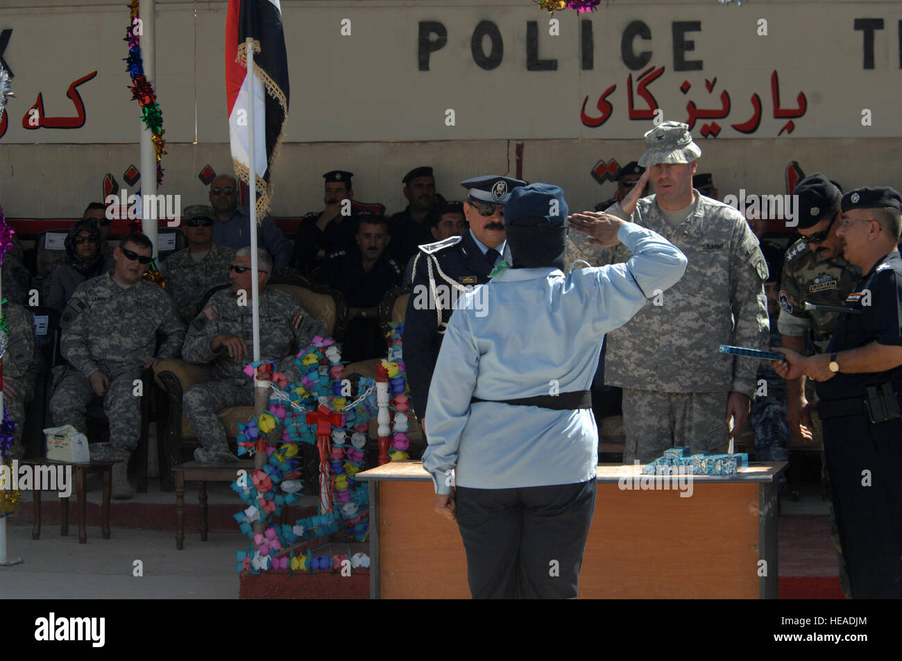 US Army Colonel David Paschal, Kommandant, 1st Brigade Combat Team, 10th Mountain Division Fort-Trommel, N.Y., macht einen Gruß nach der Präsentation ein Geschenk, ein Top-Performer aus der weiblichen Klasse nach ihrem Abschluss der Kirkuk Police Academy, Kirkuk, Irak, 23. September 2008. Stockfoto