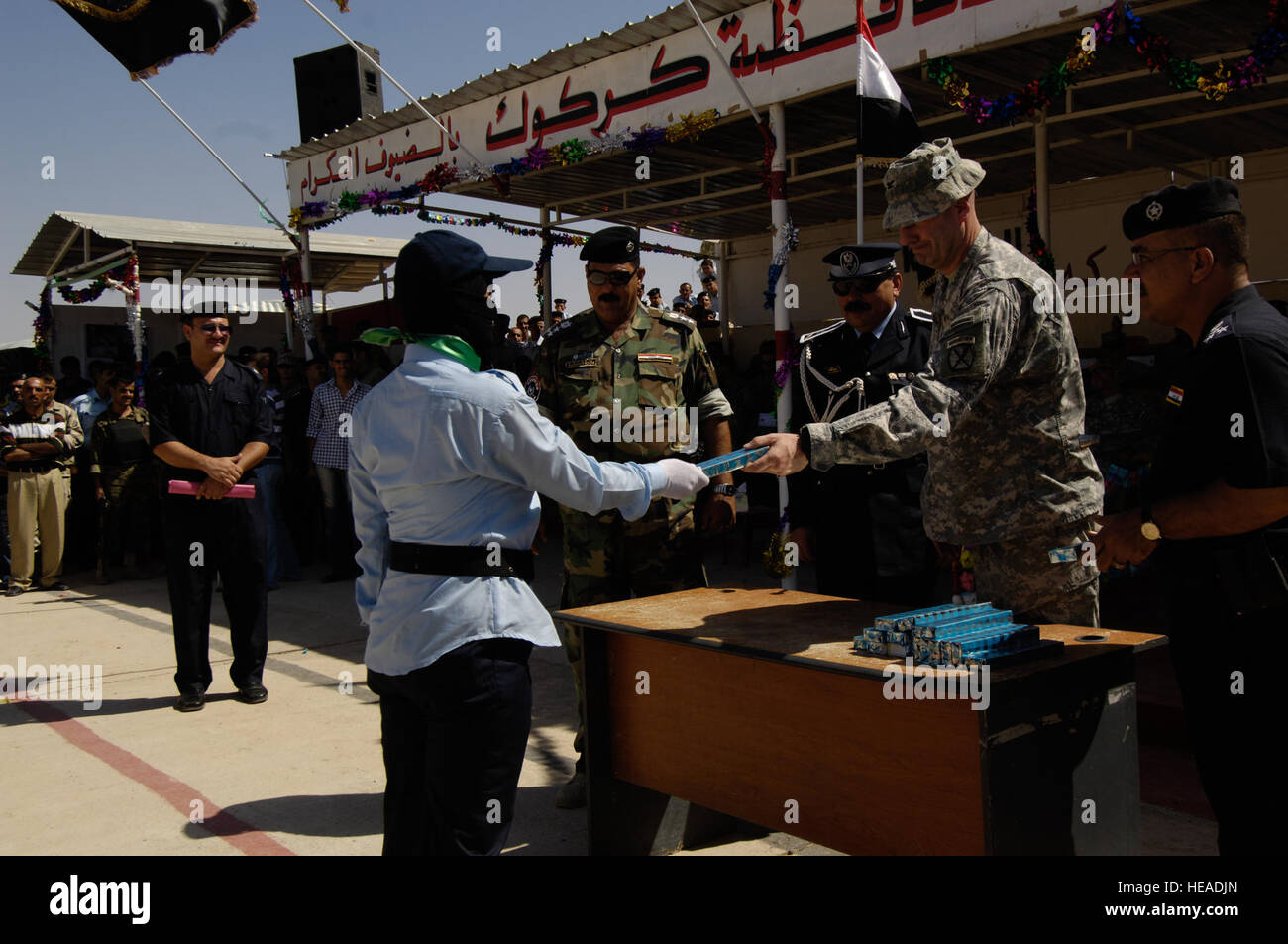 US-Armee Oberst David Paschal, Kommandant, 1st Brigade Combat Team, 10th Mountain Division, Fort-Trommel, N.Y., präsentiert ein Geschenk, ein Top-Performer aus der weiblichen Klasse nach ihrem Abschluss der Kirkuk Police Academy, Kirkuk, Irak, 23. September 2008. Stockfoto