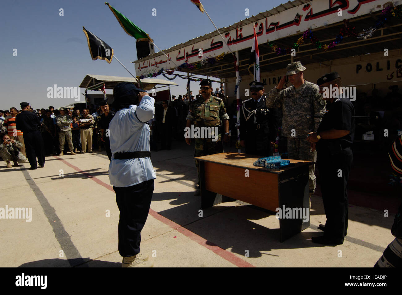 US Army Colonel David Paschal, Kommandant, 1st Brigade Combat Team, 10th Mountain Division Fort-Trommel, N.Y., macht einen Gruß nach der Präsentation ein Geschenk, ein Top-Performer aus der weiblichen Klasse nach ihrem Abschluss der Kirkuk Police Academy, Kirkuk, Irak, 23. September 2008. Stockfoto