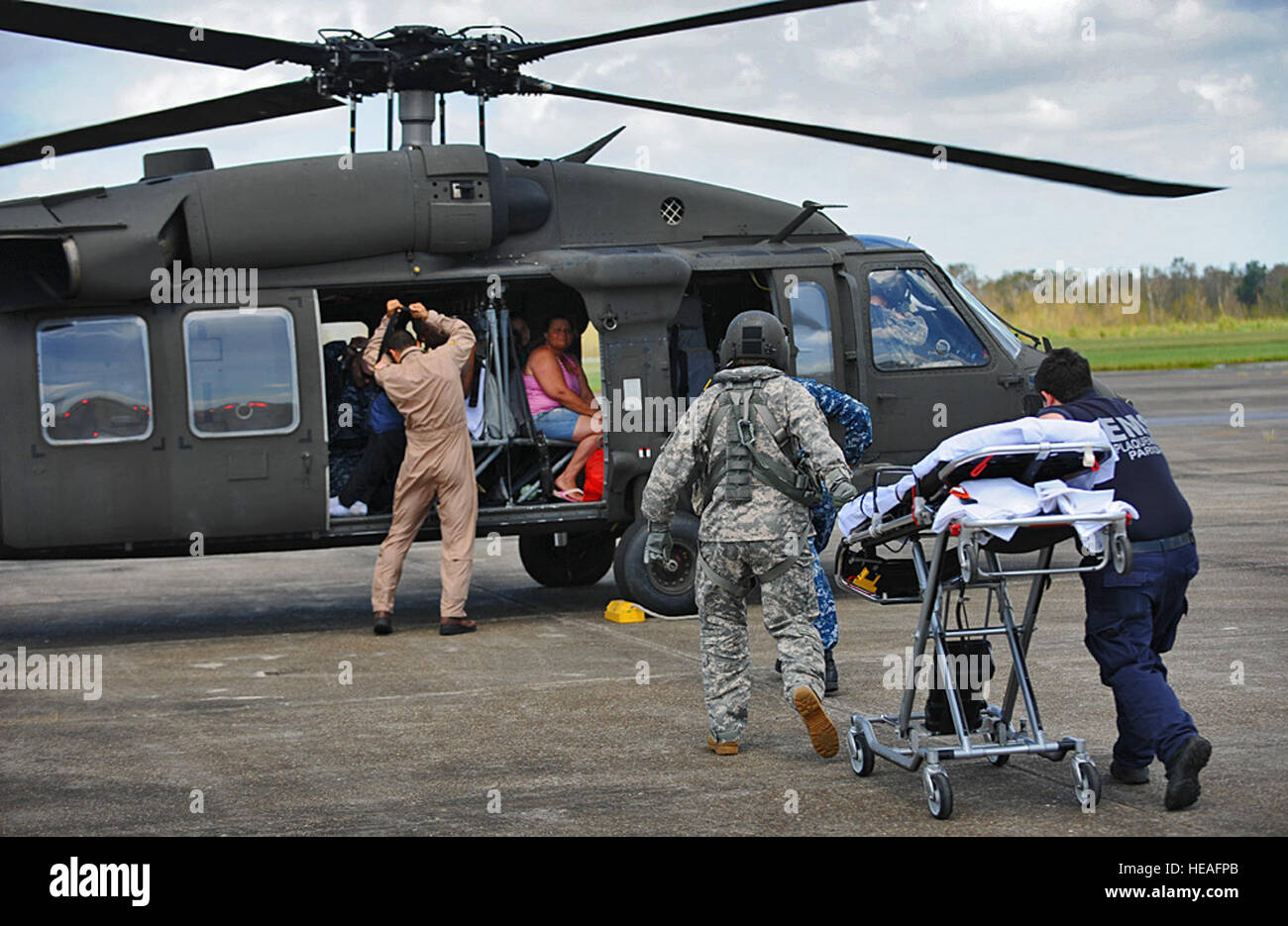 BELLE CHASSE, La - Louisiana National Gardist, Staff Sgt Gary Wange, 1. Angriff Bataillon, 244. Aviation Regiment, Naval Zweig Klinik, Belle Chasse Personal und Plaquemines Parish Emergency Management Services-Mitarbeiter und Mitglieder des 2. Bataillons der Louisiana Army National Guard, 135. Aviation Regiment bringen eine Bahre, ein UH-60 Black Hawk mit dem LANG 2-135. Allgemeine Support Aviation Battalion, Zivilisten zu übertragen, die medizinisch von Port Sulphur evakuiert , La Naval Air Station, gemeinsame Mindestreservebasis, New Orleans, 1. September 2012. Die LANG hat mehr als 6.000 Soldaten und Stockfoto