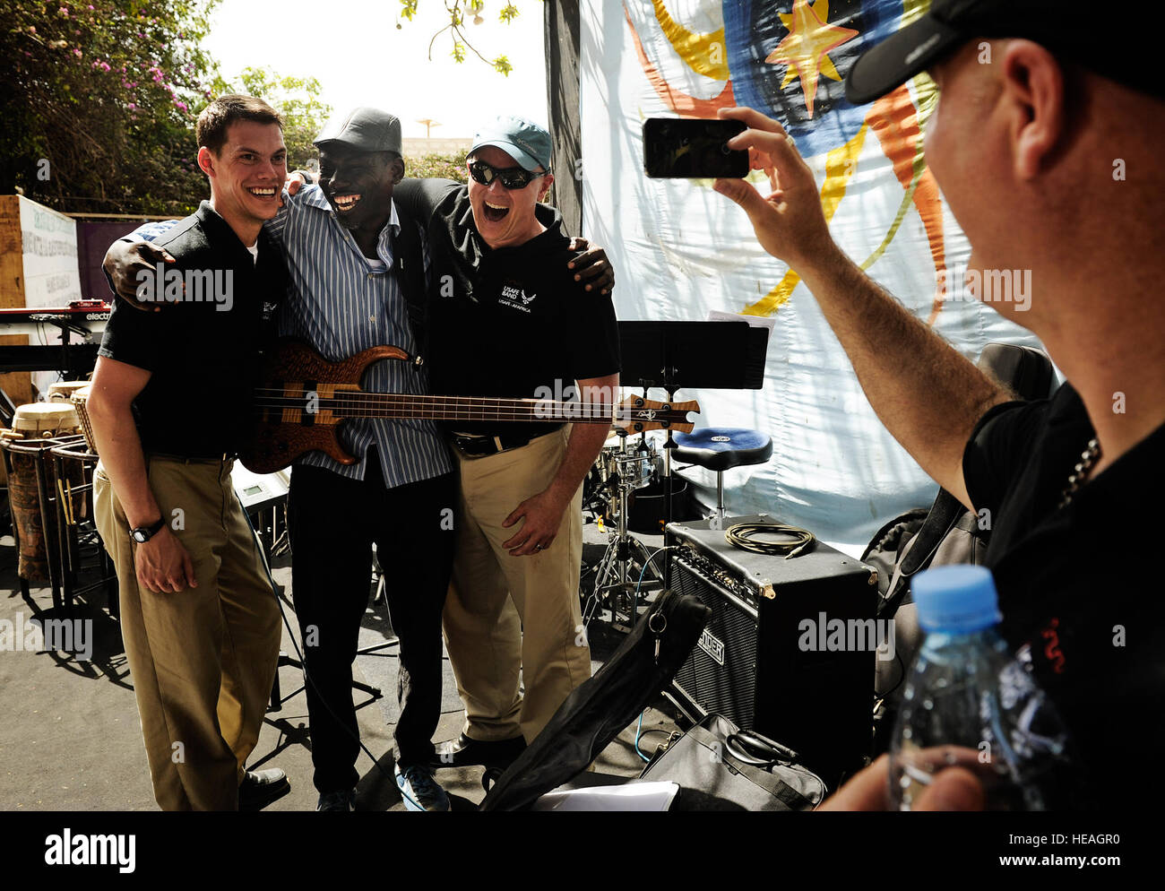 Posieren Sie Mike Mitchell Senior Airman und Staff Sgt Joseph Whitt, US Air Forces in Europa und Afrika Air Forces Kapellenmitglieder für ein Foto mit einem lokalen Musiker nach einem Konzert in Dakar, Senegal, 14. Juni 2014, an einem lokalen kulturellen Zentrum. USAFE-AFAFRICA Flieger sind im Senegal für afrikanische Partnerschaft Flug, ein Programm zur Verbesserung der Kommunikation und Interoperabilität zwischen regionalen Partnern in Afrika. Die Band spielt mehrere Locations in der Umgebung, Kindern und Musikern durch die universelle Sprache der Musik zu begeistern.  Staff Sgt. Ryan Crane) Stockfoto