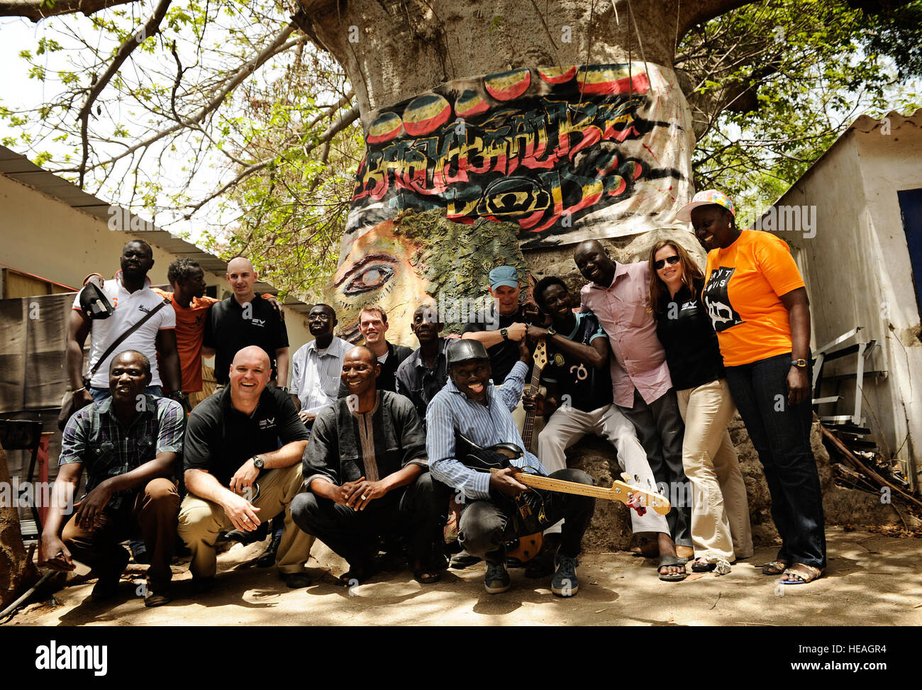 Mitglieder der US-Luftstreitkräfte in Europa und Afrika Air Force Band posieren für ein Foto mit lokalen Musikern vor einem berühmten lokalen Baum, genannt "The Protector", nach einem Konzert in Dakar, Senegal, 14. Juni 2014, an einem lokalen kulturellen Zentrum. USAFE-AFAFRICA Flieger sind im Senegal für afrikanische Partnerschaft Flug, ein Programm zur Verbesserung der Kommunikation und Interoperabilität zwischen regionalen Partnern in Afrika. Die Band spielt mehrere Locations in der Umgebung, Kindern und Musikern durch die universelle Sprache der Musik zu begeistern.  Staff Sgt. Ryan Crane) Stockfoto