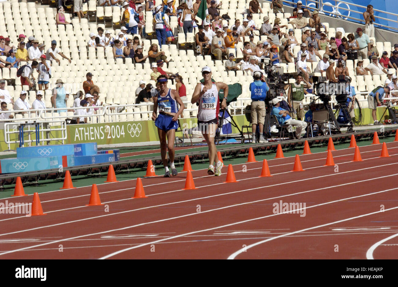 US Armee Sgt. John Nunn übergibt Kazakstans Valeriy Borisov 20K Laufresultaten Wettbewerb während der Olympischen Spiele 2004 im Olympiastadion in Athen, am 20. August 2004.   Master Sergeant Lono Kollars) (veröffentlicht) Stockfoto