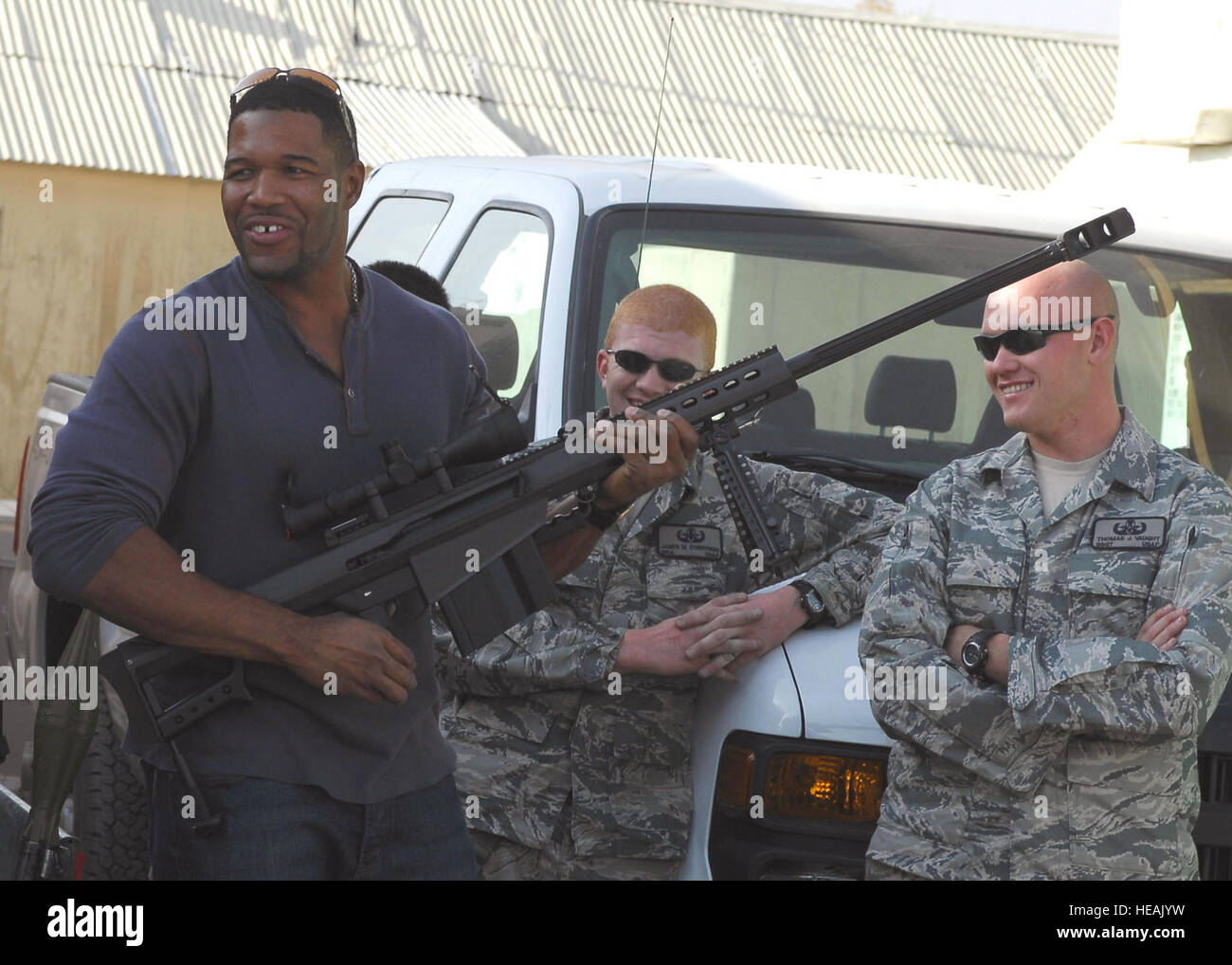 Michael Strahan, Ansager mit Fox NFL Sunday, kümmert sich eine Long-Range Gewehr M107 während des Besuchs der 755. Air Expeditionary Group Explosive Ordnance Disposal Flug 6. November 2009, Bagram Airfield, Afghanistan.  Senior Airman James Dobrynski (links) und Staff Sgt Thomas Vaught blicken auf. Die NFL Sunday Team von Curt Menefee, Terry Bradshaw, Howie Long, Michael Strahan, Jimmy Johnson und Jay Glazer sollen als eine Hommage an das Engagement von Amerikas Servicemembers von hier aus live 8 November ausgestrahlt.  Senior Airman Felicia Juenke) Stockfoto