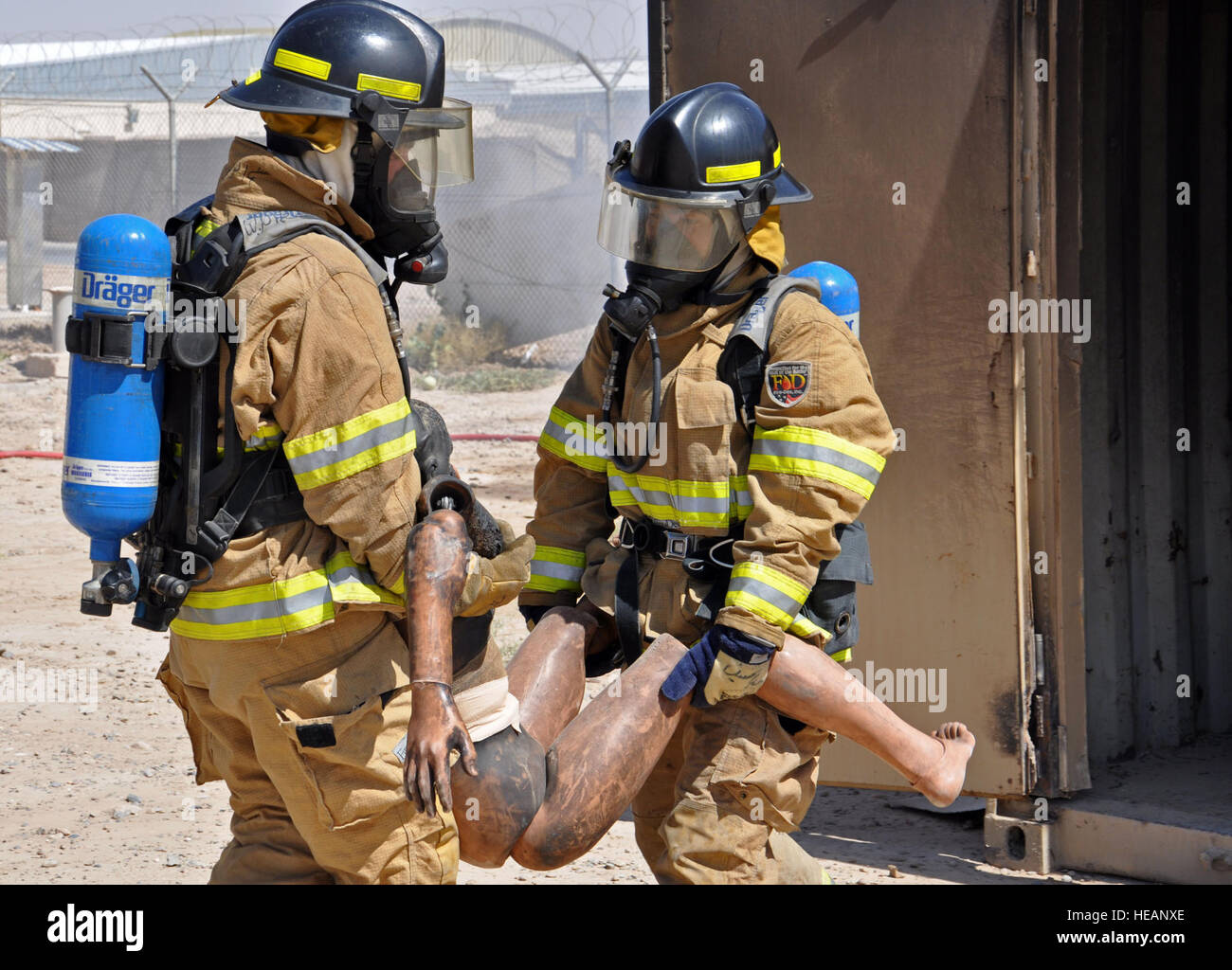 Afghanische Luftwaffe Feuerwehrleute Praxis einen Dummy aus einem brennenden Gebäude während einer Übung 8. September 2013 in Kandahar Airfield, Afghanistan zu retten. Im Jahr 2013, Berater mit NATO Air Training Command-Afghanistan, haben damit begonnen, Schritt weg von der Ausbildung wie die Afghanen selbst beginnen, Schulung und Betrieb der Feuerwehr zu übernehmen. Capt Anastasia Wasem) Stockfoto