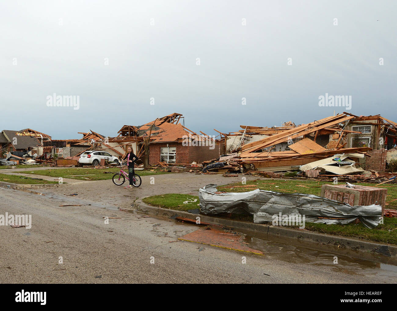 Ein junges Mädchen hält ihr Fahrrad um Einsatzkräfte in ihrer Nachbarschaft zu beobachten, am 21. Mai 2013 nach ein massiven Tornado in Moore, Oklahoma aufsetzten  Techn. Sgt. Roberta A. Thompson) Stockfoto