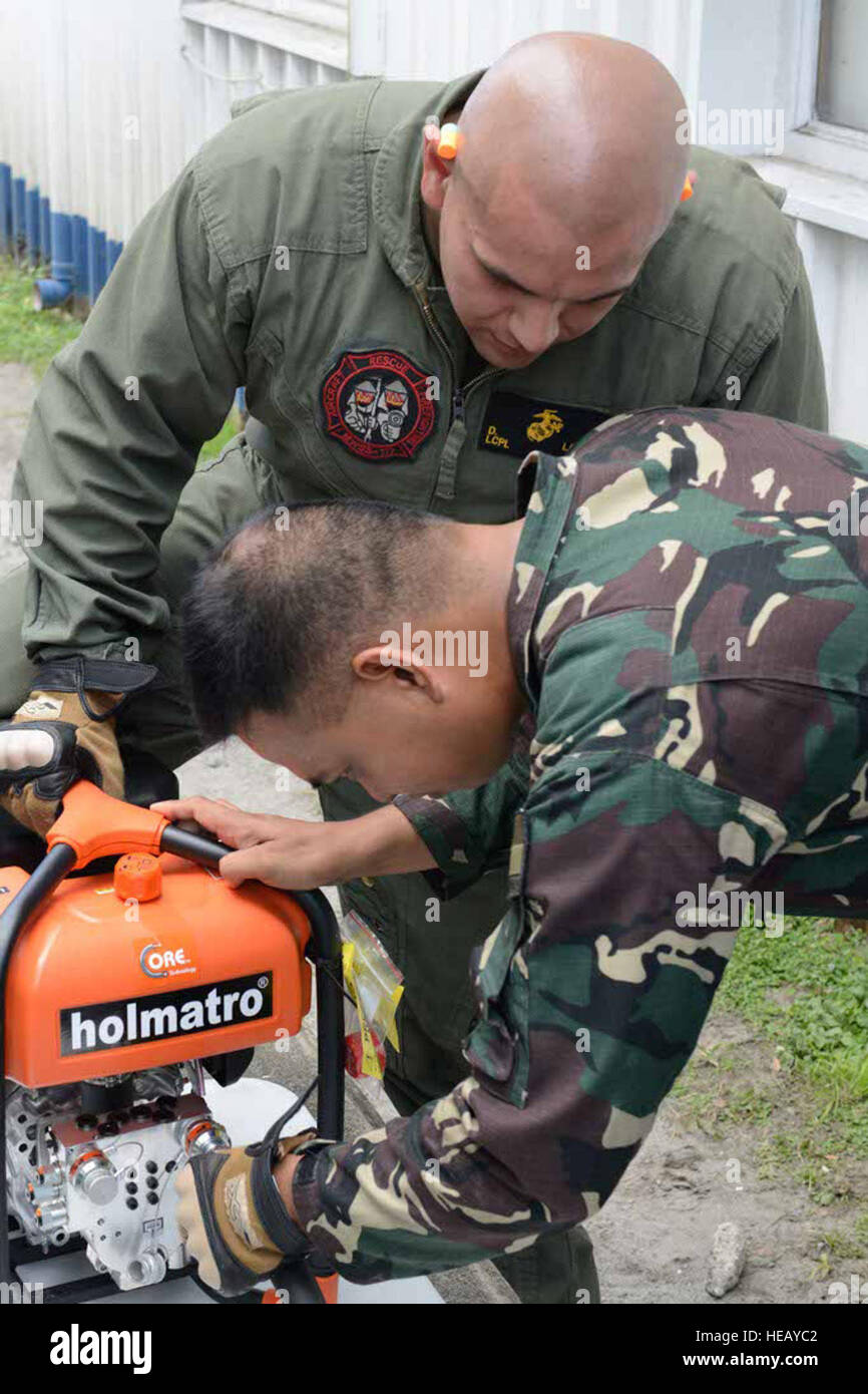 Philippine Air Force Staff Sgt Henry B. San Juan inspiziert Flugzeug Absturz Bergegerät mit U.S. Marine Corps Lance Cpl. David Landa während einer Fortbildungsveranstaltung 6. Mai 2014 auf Clark Air Base, Philippinen. Im 30. Jahr ist Balikatan einen jährlichen Übung, die die Interoperabilität zwischen der Streitkräfte der Philippinen und US-Militär in ihrem Engagement für regionale Sicherheit und Stabilität, humanitäre Hilfe und Katastrophenhilfe stärkt. Das Training ist Bestandteil einer Reihe von gemeinsamen Veranstaltungen zur Verbesserung der Effizienz zwischen Flugzeugen Rettung und Brandbekämpfung Marin Stockfoto