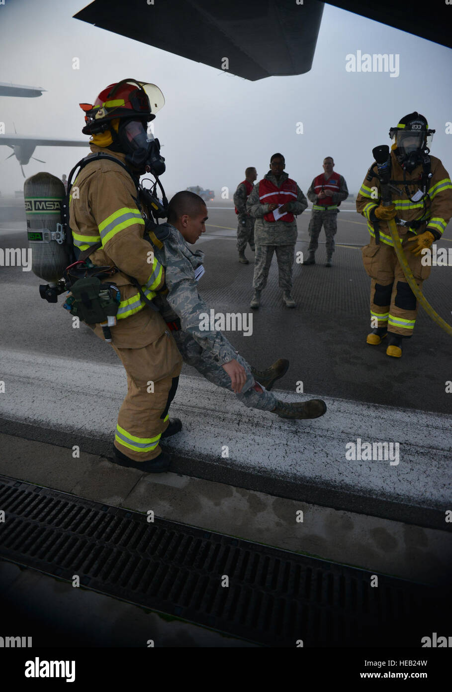 Ein Feuerwehrmann wird eine verletzte Passagier aus dem Wrack der simulierten Flugzeugabsturz unter den wachsamen Augen des Inspektionsteams Flügel als Teil der schweren Unfall-Antwort-Übung auf Ramstein Air Base, Deutschland, 18. Oktober 2014 entfernt. Mitglieder der US Air Force und Host Nation Agenturen eine Partnerschaft bei der Durchführung einer Reaktion und die Wiederherstellung Übung in Vorbereitung auf mögliche reale Vorfälle. Senior Airman Hailey Haux) Stockfoto