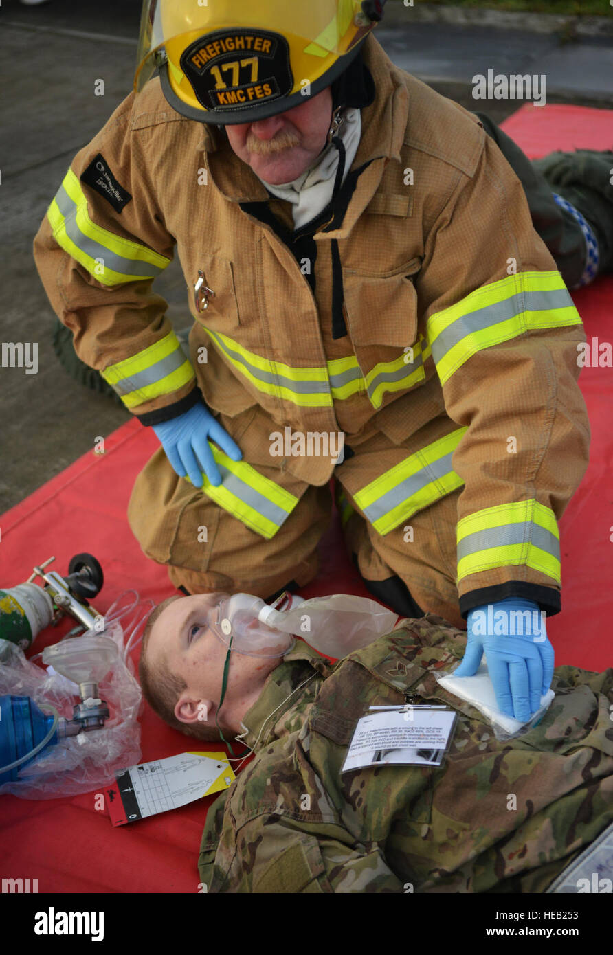 Ein Feuerwehrmann kümmert sich um einen verwundeten Flieger nach einer simulierten Flugzeugabsturz während der schweren Unfalls Antwort Übung auf der Ramstein Air Base, Deutschland, 18. Oktober 2014. Mitglieder der US Air Force und Host Nation Agenturen eine Partnerschaft bei der Durchführung einer Reaktion und die Wiederherstellung Übung in Vorbereitung auf mögliche reale Vorfälle. Senior Airman Hailey Haux) Stockfoto