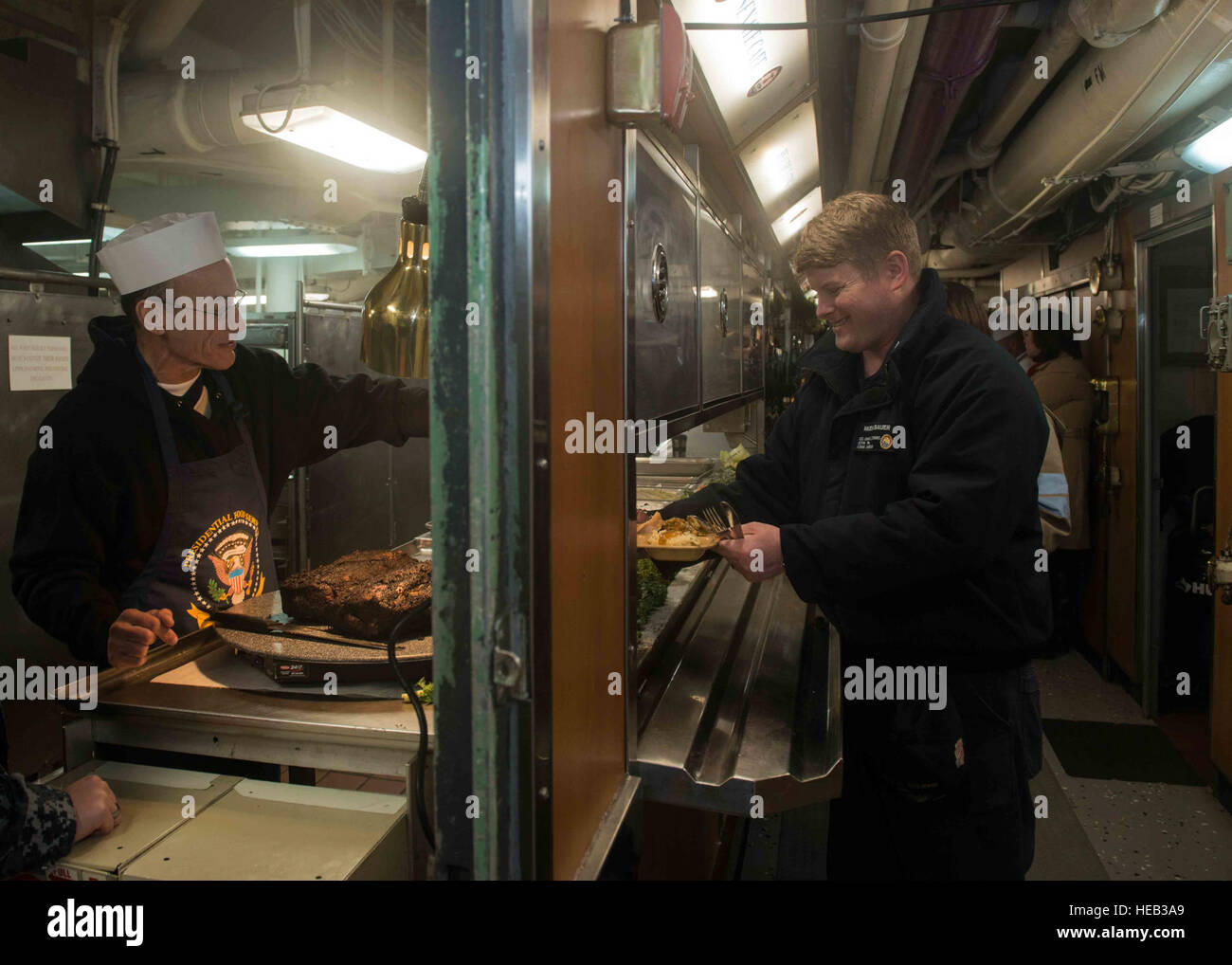 151225-N-KM956-072 BREMERTON Wash (25. Dezember 2015) - Ernie Samaras, von Seattle, dient Hochrippe, innere Kommunikation Elektriker 2. Klasse Daniel Muehlbauer aus Flagstaff, Arizona, in der hinteren Galley an Bord der USS John C. Stennis (CVN-74). Stennis' Crew ist derzeit in der Port-Ausbildung für zukünftige Bereitstellungen.  Masse der Kommunikationsspezialist 3. Klasse Aime Lykins / veröffentlicht) Stockfoto