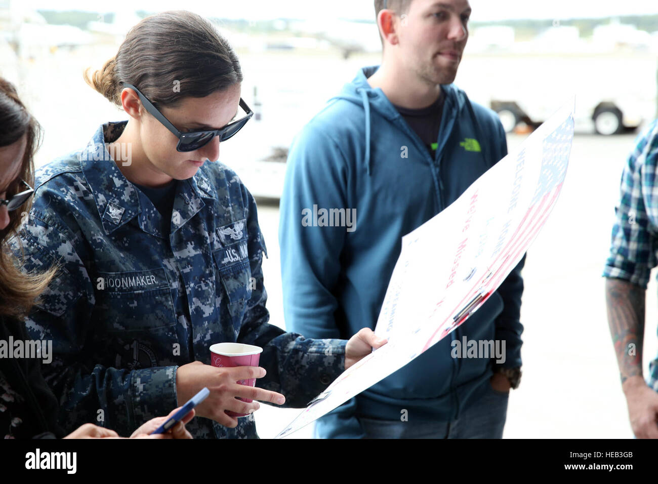 150830-N-DC740-019 OAK HARBOR, Washington (30. August 2015) Luftfahrt Elektriker Mate 3. Klasse Alysha Schoonmaker, zugeordnet zu Patrol Squadron (VP) 1, liest einem Willkommen Zuhause Plakat von ihren Eltern nach der Rückkehr zur Naval Air Station Whidbey Island von der Bereitstellung. VP-1 durchgeführt Anti-u-Bootbekämpfung zusammen mit nachrichtendienstlichen, Aufklärung und Überwachung Missionen in der 7. Flotte Verantwortungsbereich.  Masse der Kommunikationsspezialist 2. Klasse John Hetherington Stockfoto